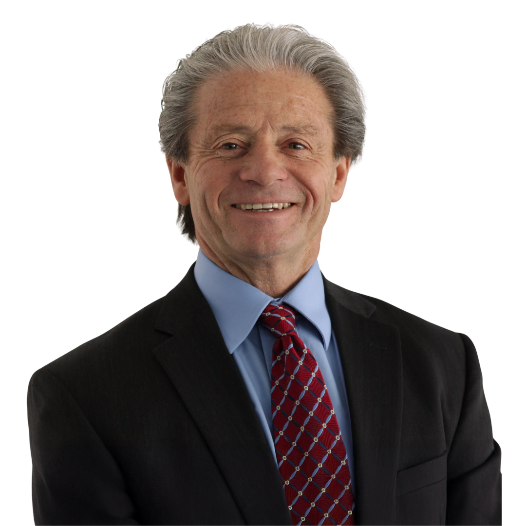 Smiling man with gray hair wearing a black suit, white shirt, and blue tie against a plain white background.