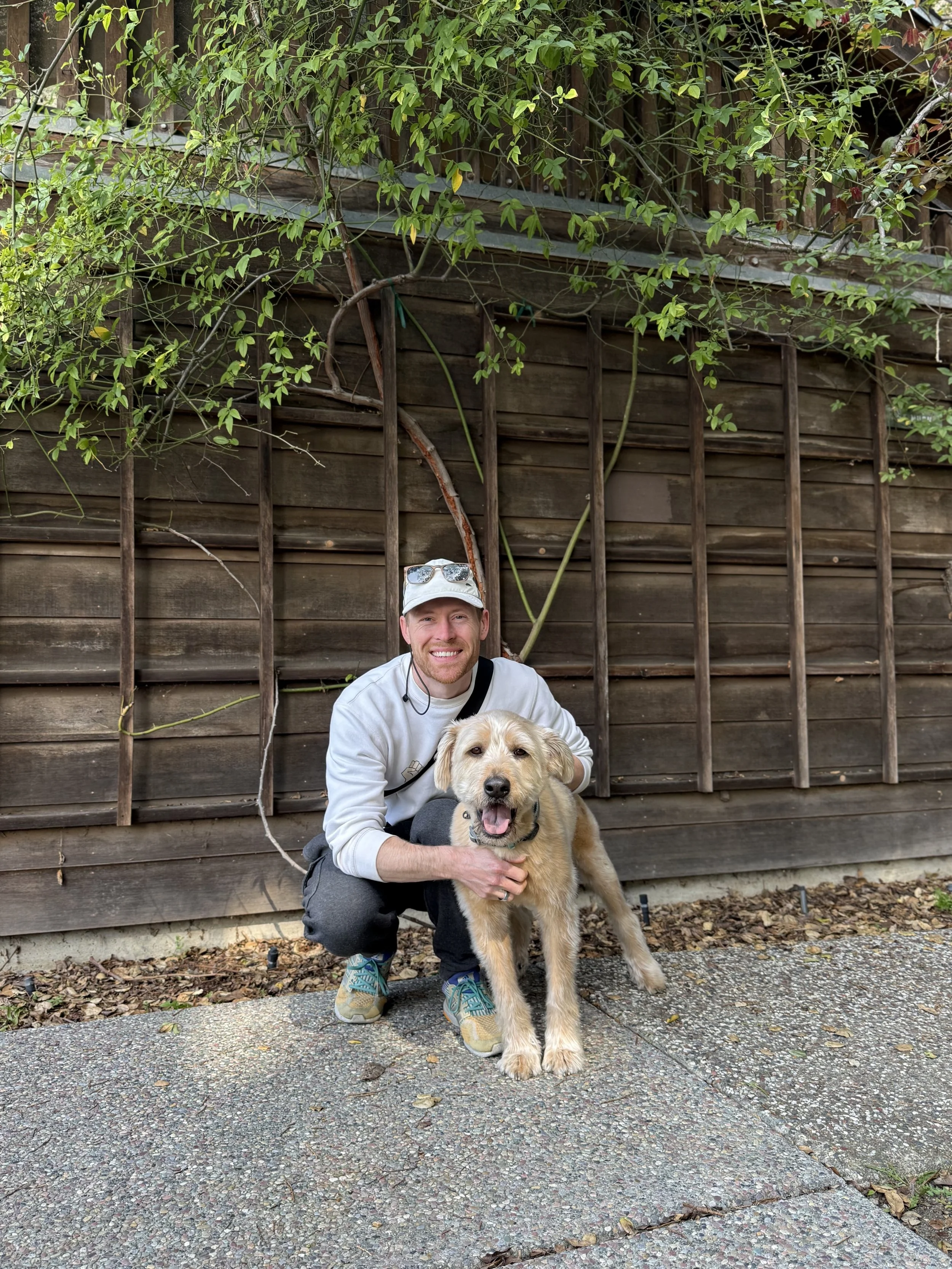 A mold dog and his handler in front of a tree