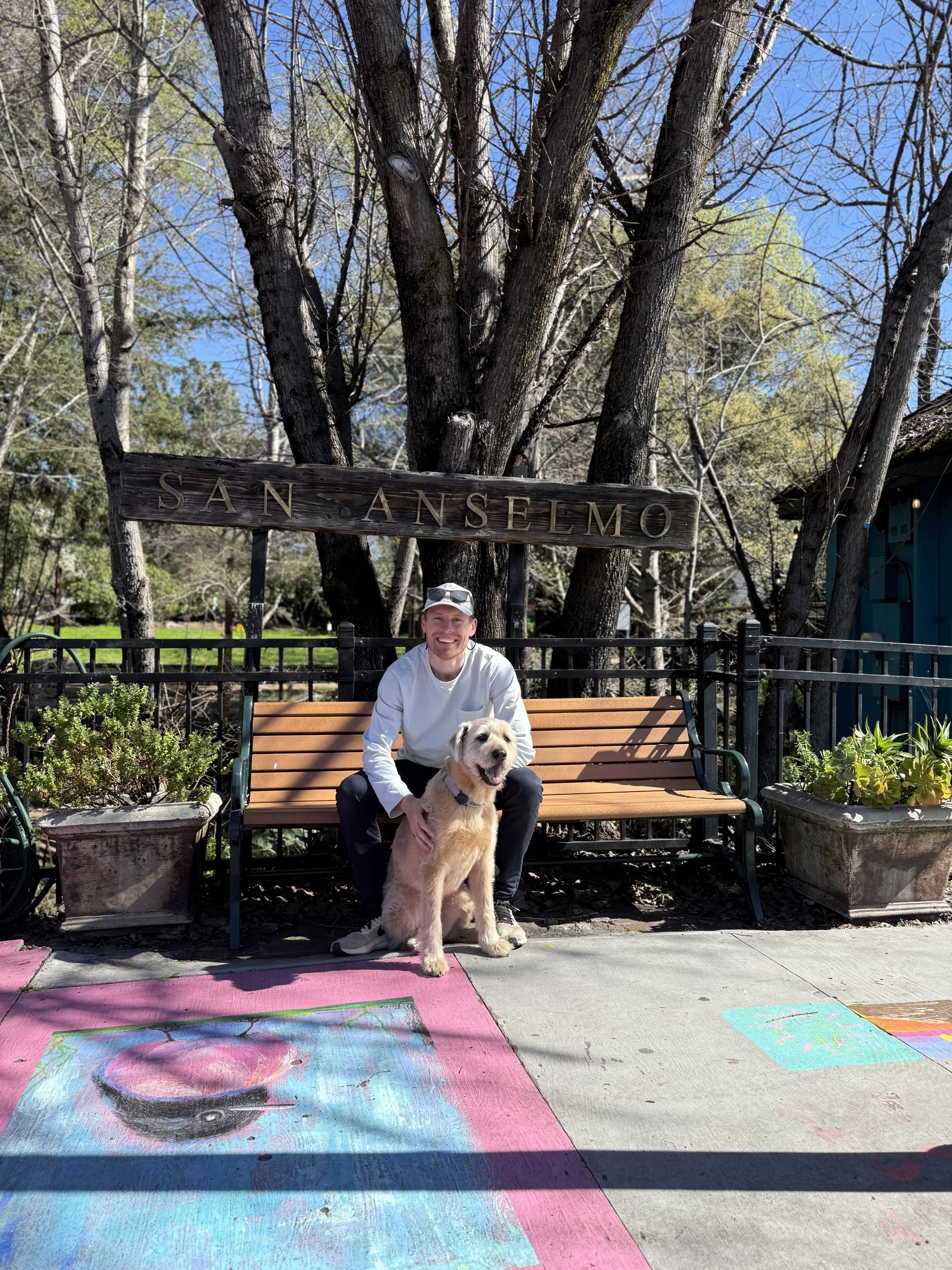 A mold dog and his handler in front of a San Anselmo sign