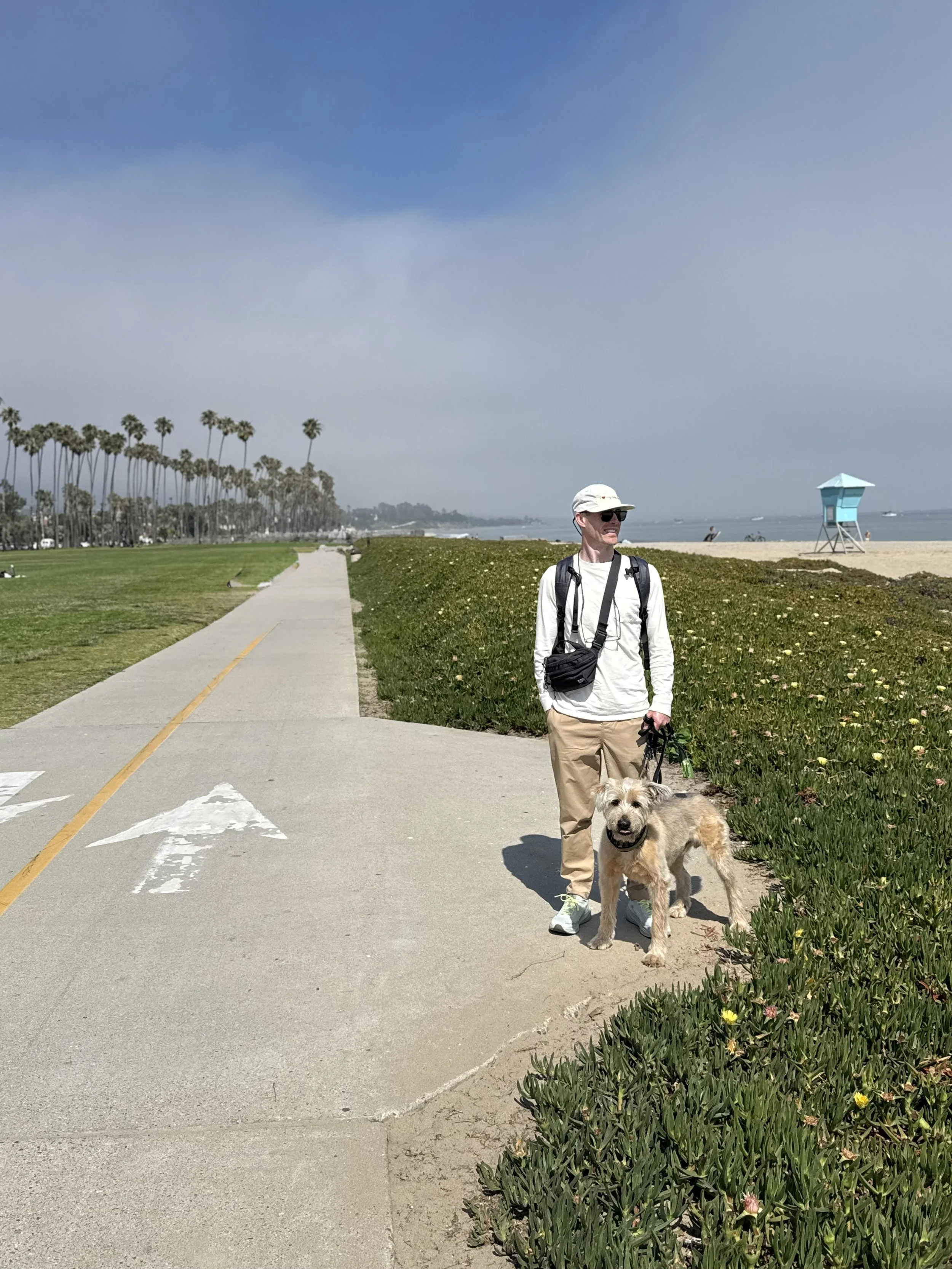 A man and his mold dog on a beach in Santa Barbara