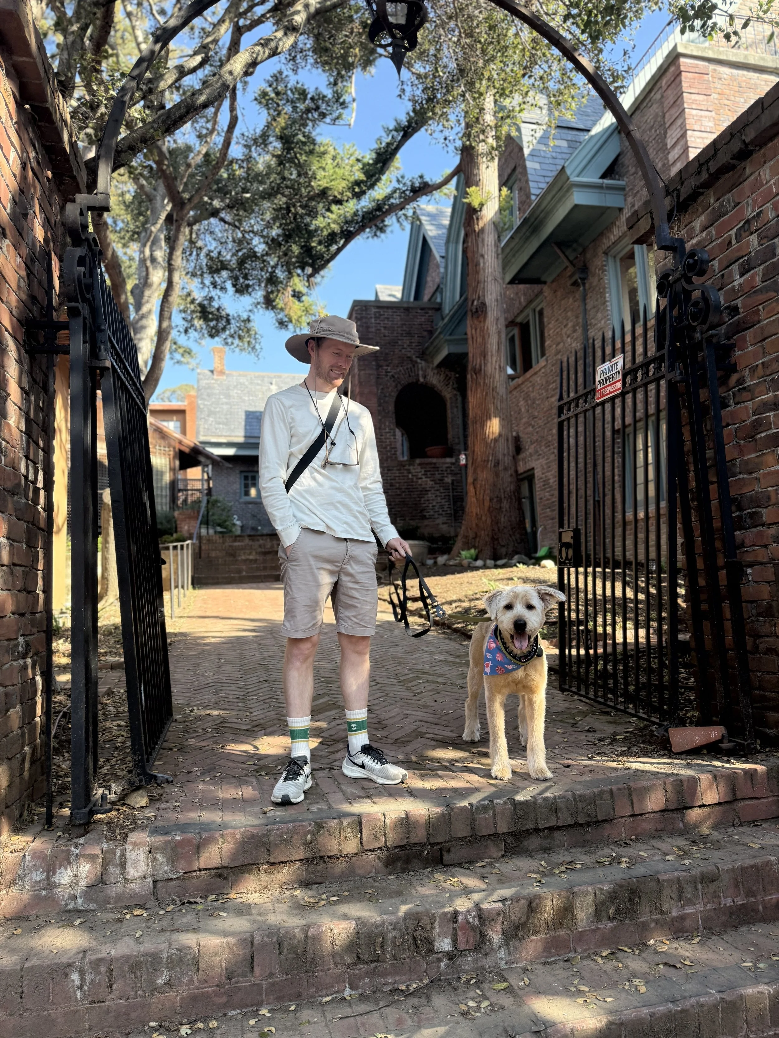 A mold dog and his trainer standing in front of home in the bay area