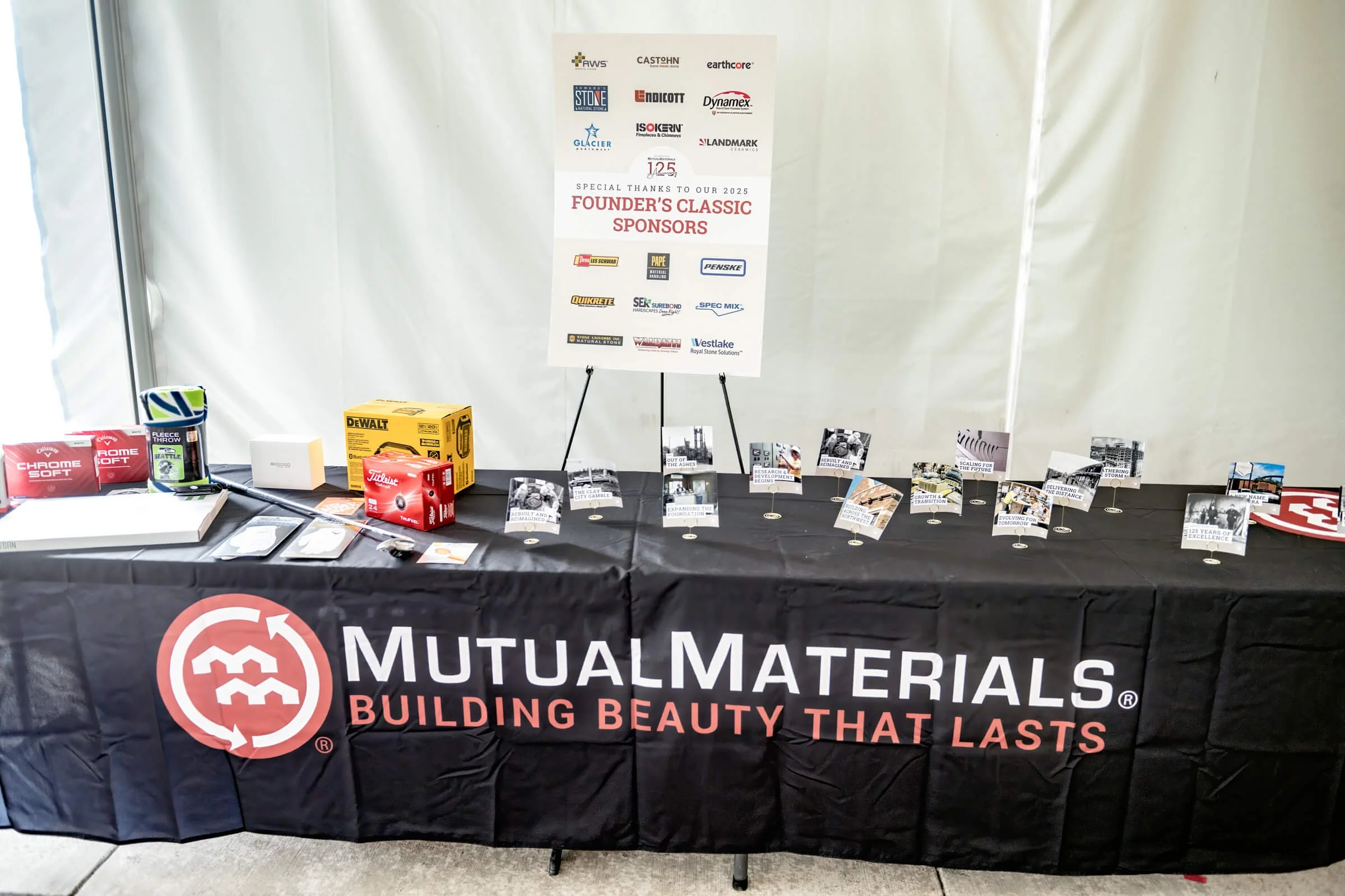 Raffle setup featuring extra table toppers (moved mid-event) and a sponsor poster showcased in the background.