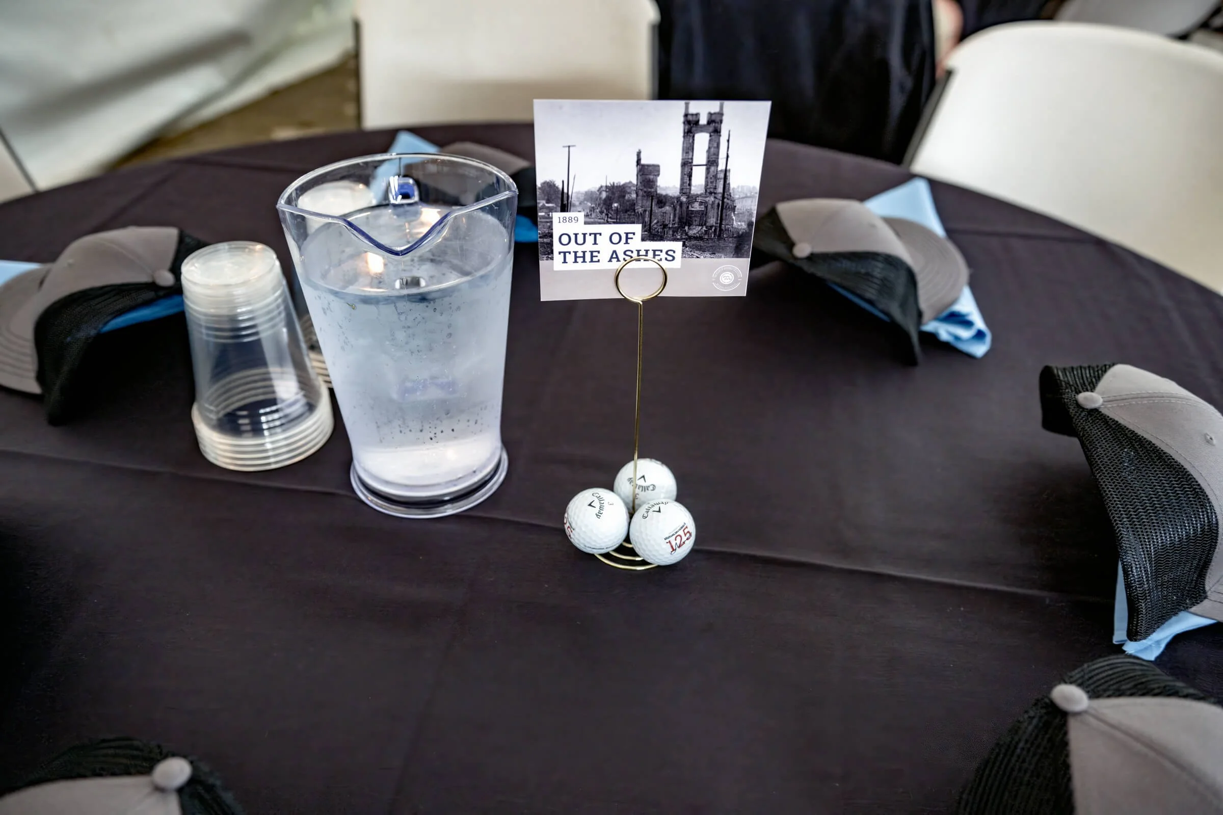 Small-scale table signage featuring unique historical events at each table, paired with extra branded golf balls for guests to take home.