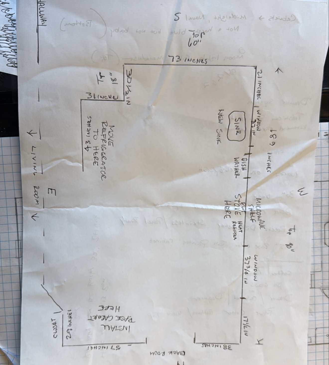 Hand-drawn sketch of a workspace layout with labeled measurements and notes on a crumpled piece of paper.