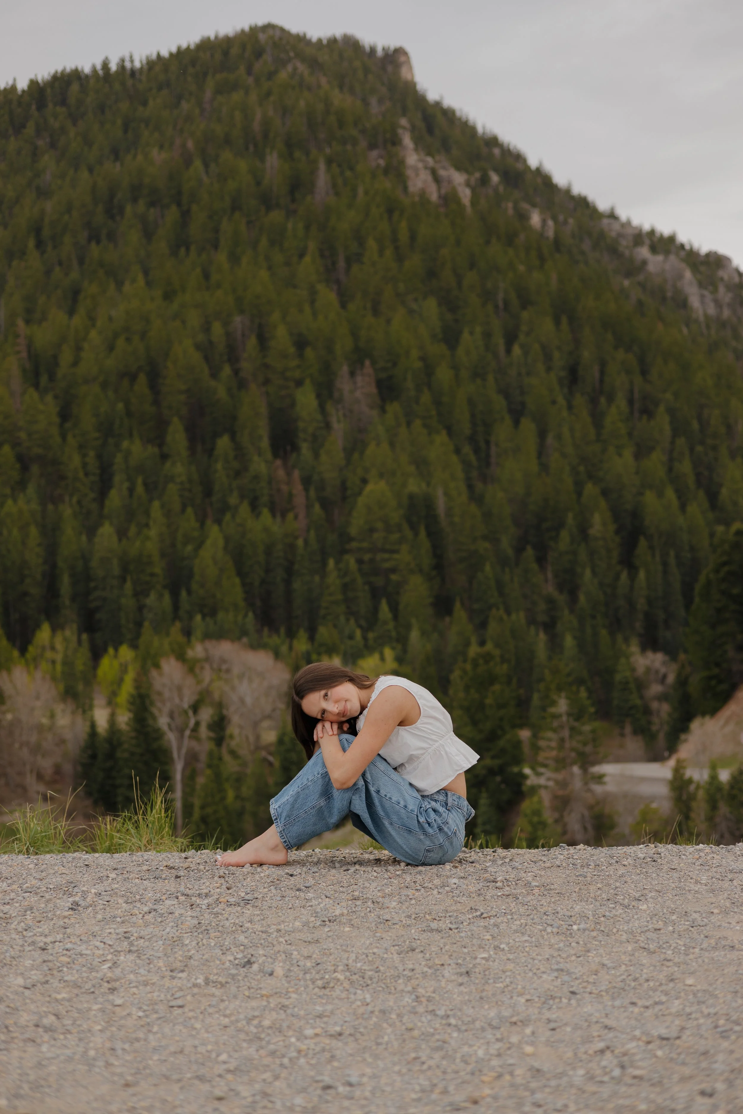 girl sitting on the ground hugging her knees
