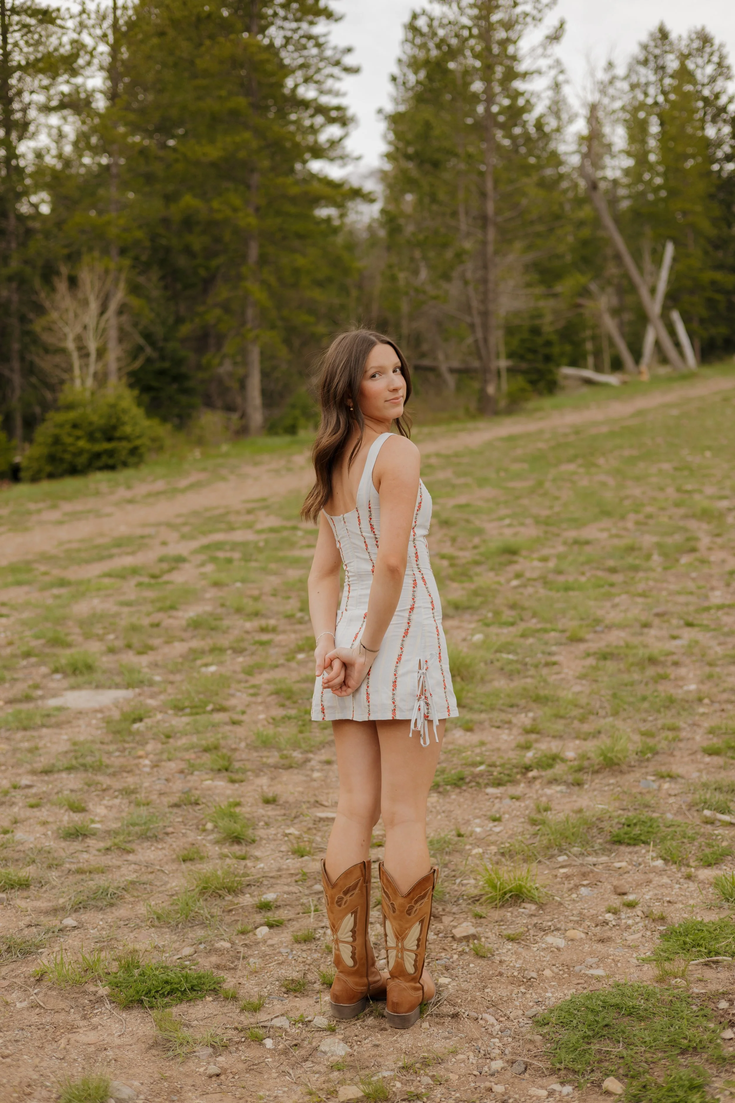 girl looking over her shoulder with her hands behind her back