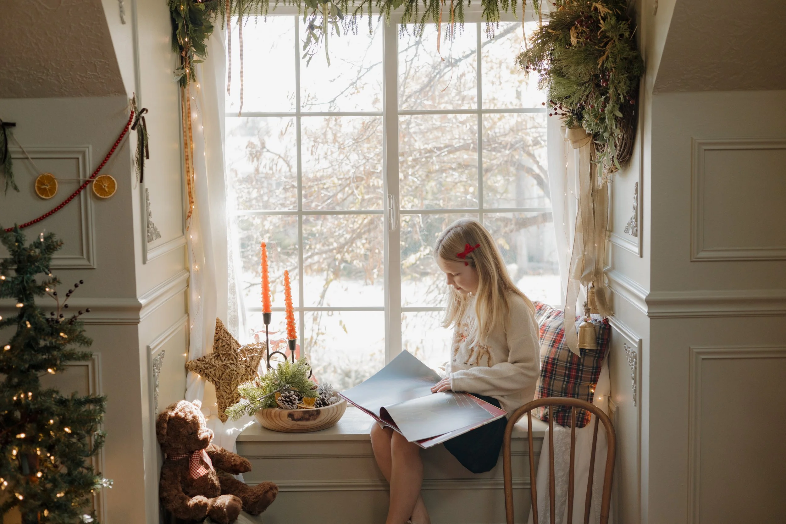 girl sitting in window sill reading book