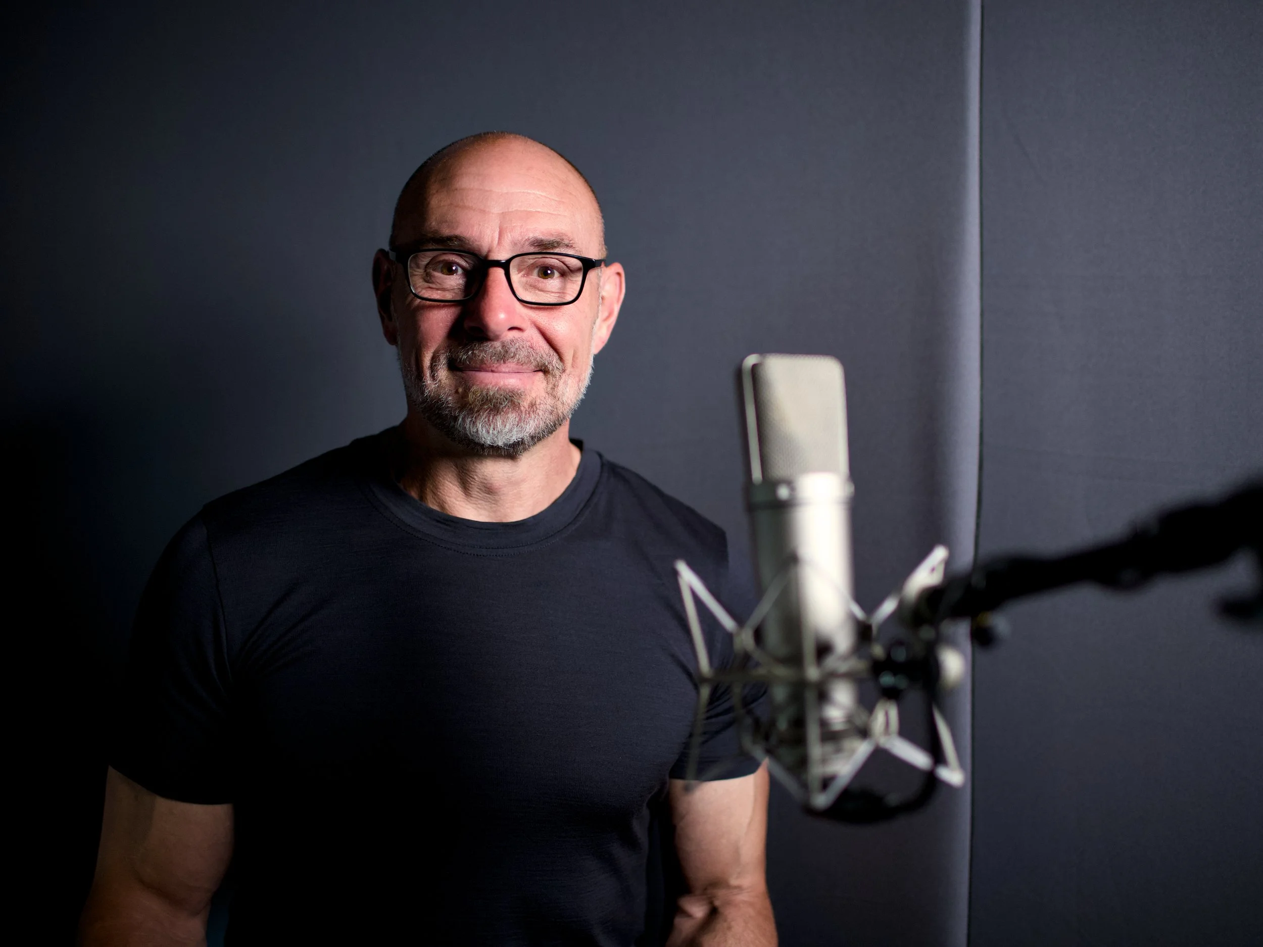 A voiceover artist standing in front of a professional microphone in the Sound Matters studio, ready to record.