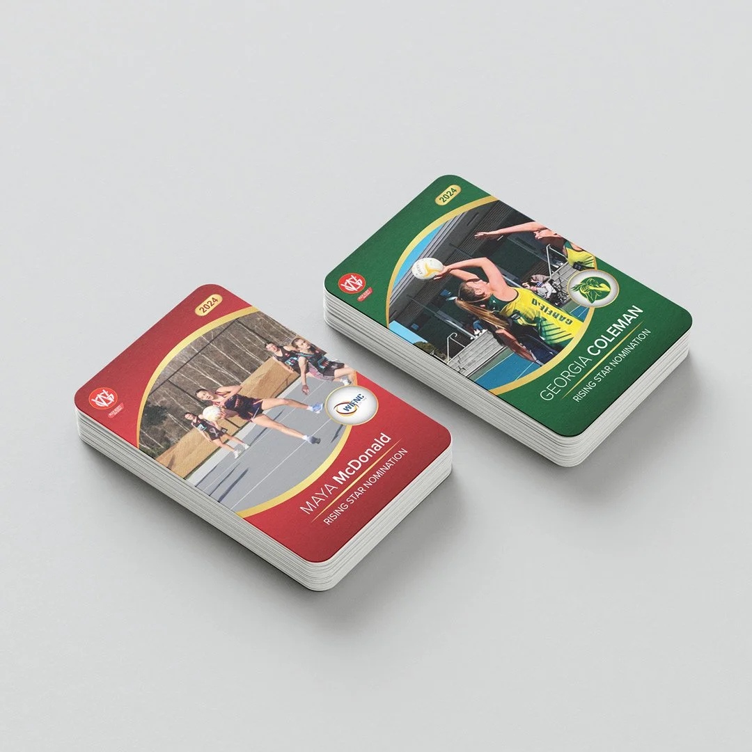 Stacks of sports trading cards featuring female athletes, with one card showing a volleyball player and another showing a volleyball player from Georgia College.