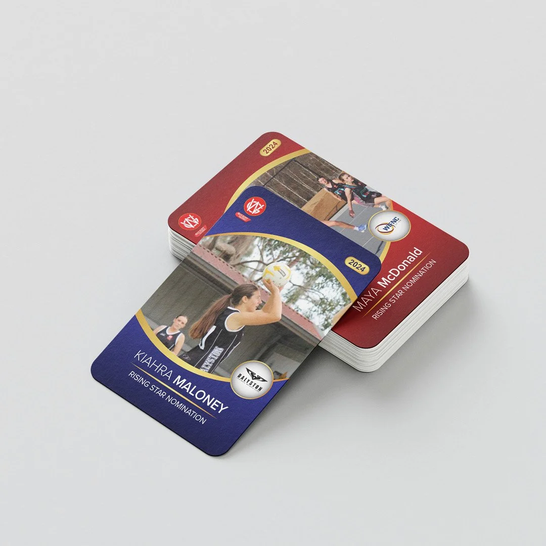 Stack of colorful sports trading cards featuring female volleyball players, with one card pulled out showing a player preparing to serve. The cards are for the 2024 season and include names Kayhira Maloney and Maya A McDonald, with titles 'Rising Star Nomination' and team logos.