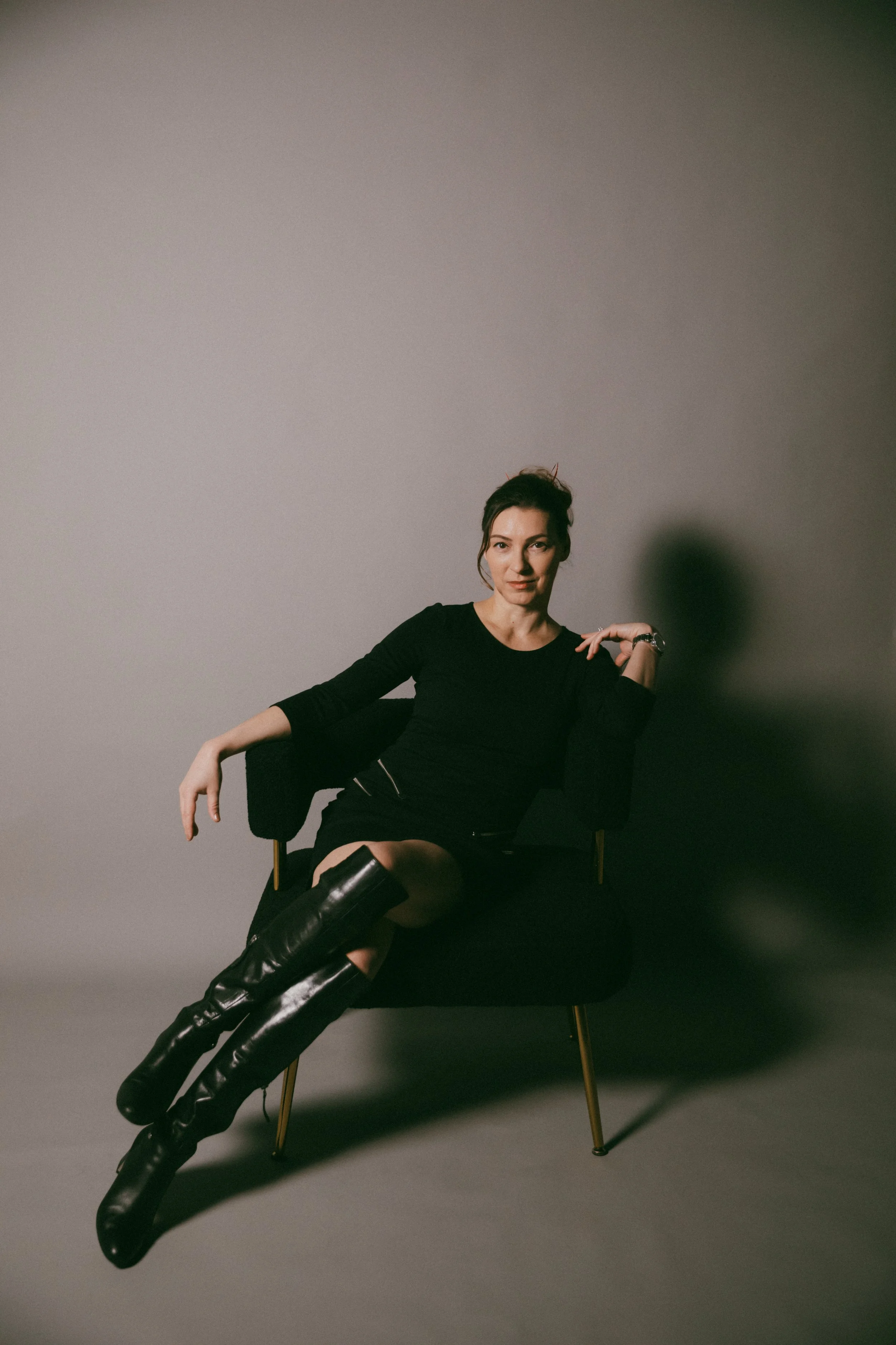 Dr. Kat seated in a minimalist studio portrait representing the 30-day Biological Leadership intensive and private nervous system mentorship for high-level professionals.