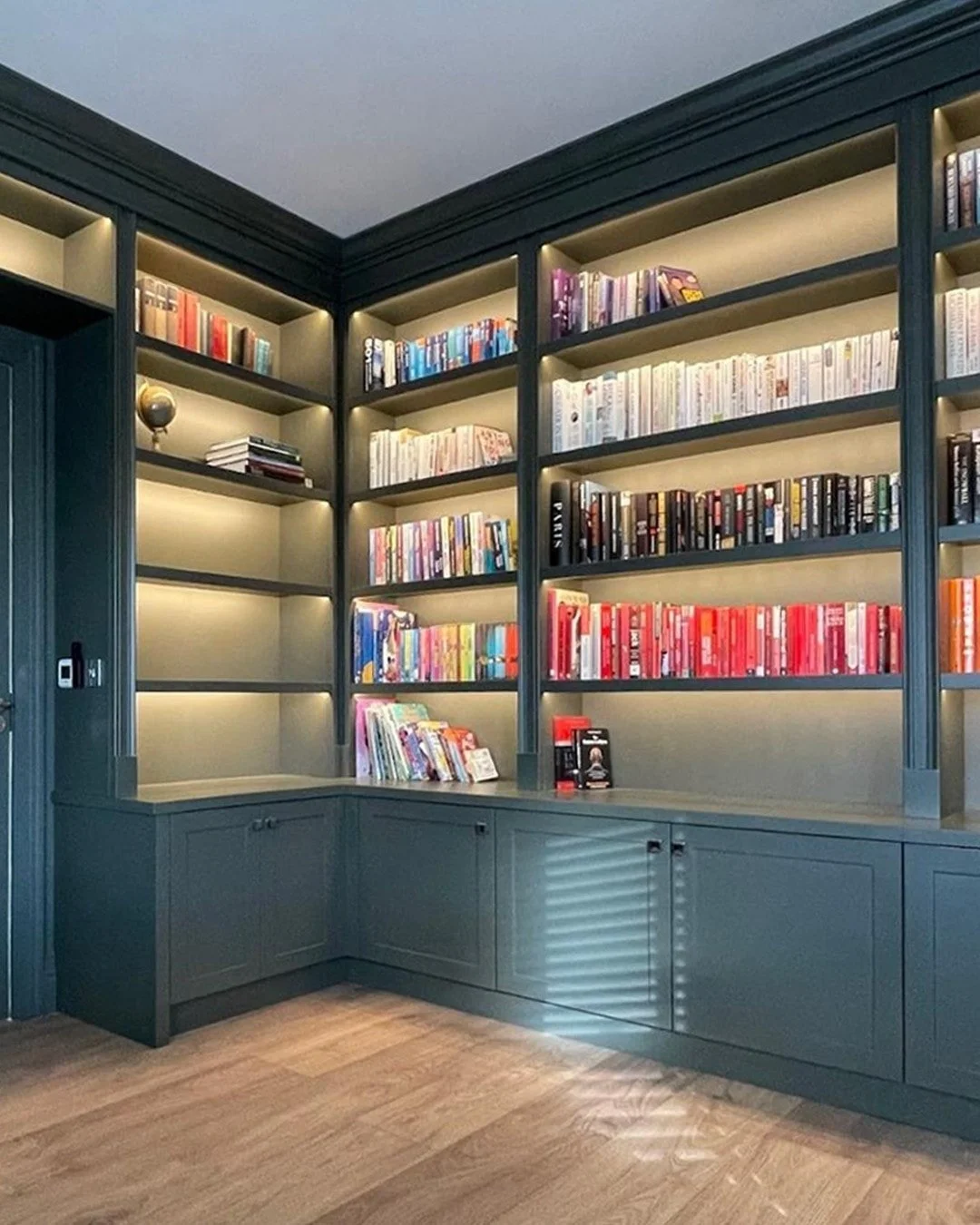 A workspace that makes getting tasks done feel effortless. 
This home office combines practicality and style with open shelves framed by moulded pillars, shaker-style cabinets for discreet storage, and a stained oak desk that ties it all together. Wa