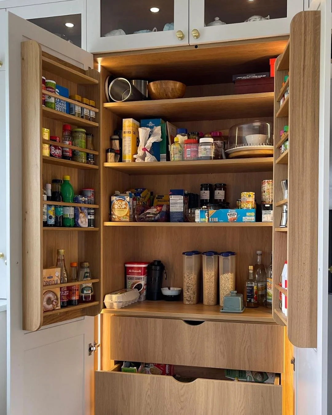 We crafted two types of storage, each solving a different everyday challenge. 
In the kitchen, the larder makes life easier with oak spice racks, deep drawers, and warm LED lighting that keeps everyday essentials organised and ready the moment they&r