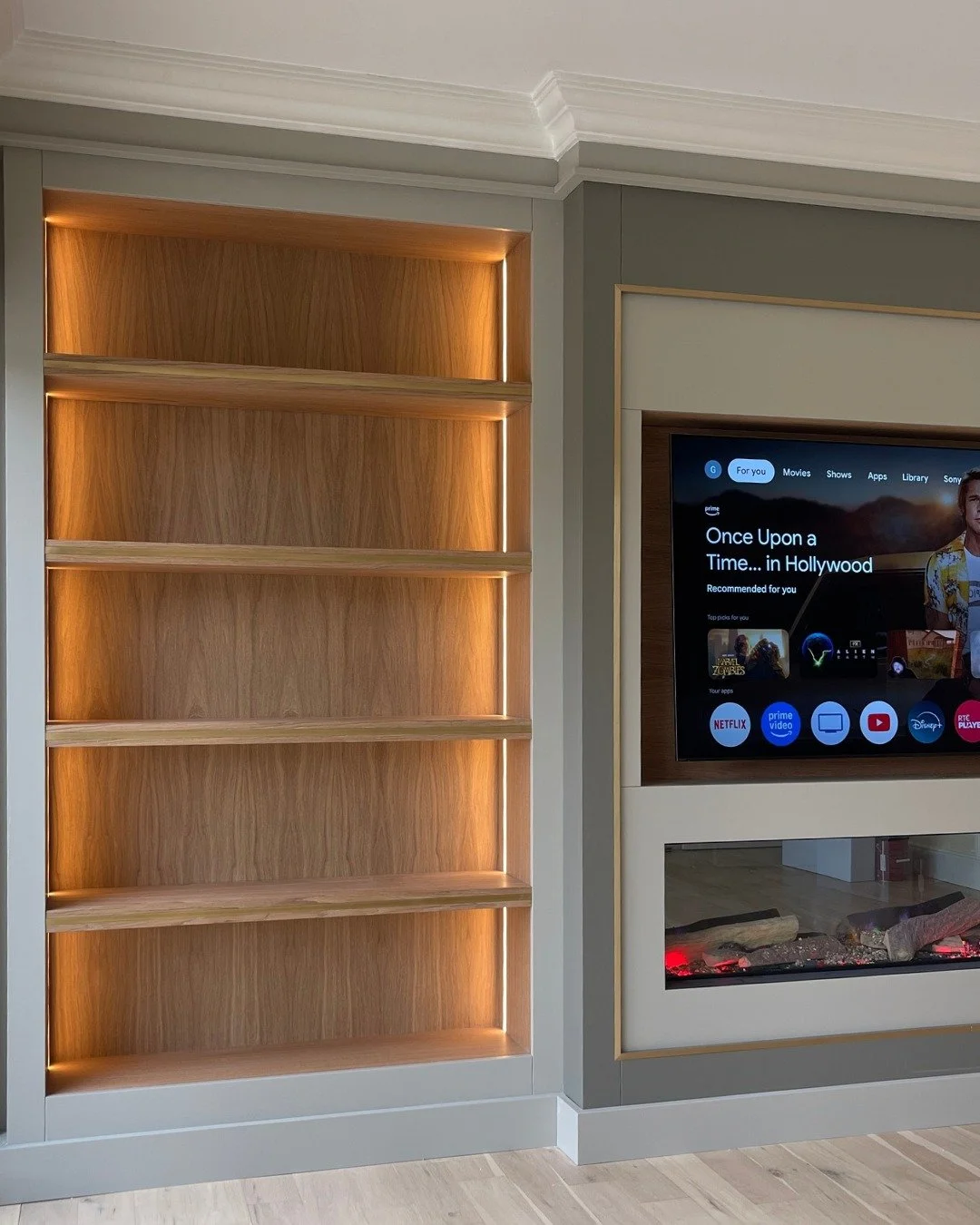 This media wall settles naturally into the room, finished in Colourtrend&rsquo;s 'Covert Feather' with 'Winter Wren' for the TV surround that adds quiet contrast. Stained oak display cabinets and grain-matched oak shelving and internal LED strip ligh