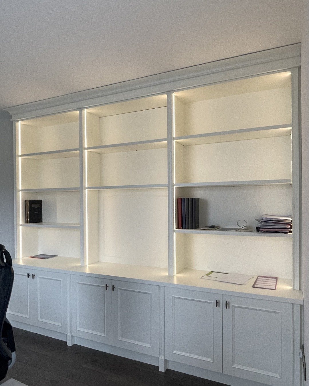 Some spaces in the home quietly support the day, while others come alive as evening approaches. 
The bookcase finished in &lsquo;Wimborne White&rsquo; with warm oak interiors keeps work essentials organised, featuring open shelves for books and close