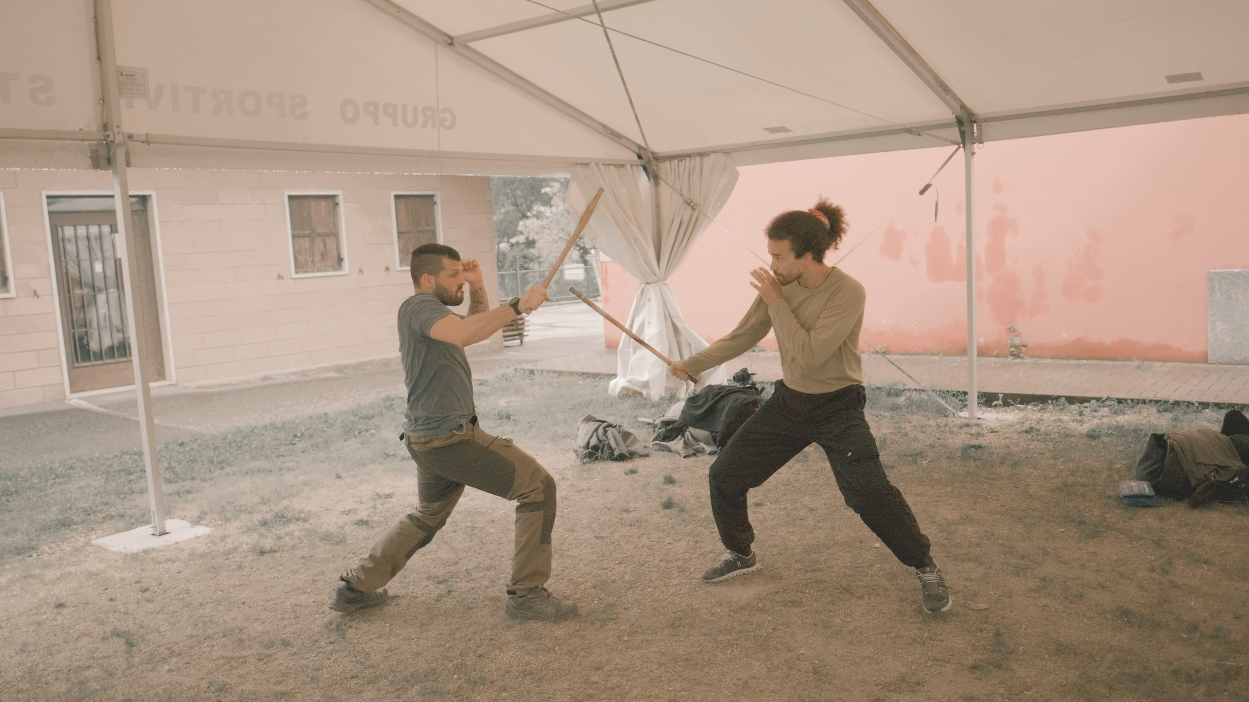 Zwei Männer, die sich in einer Zwiegespräch-Kampfensemble auf einer Tierunterhaltung prügeln, unter einem weißen Pavillon