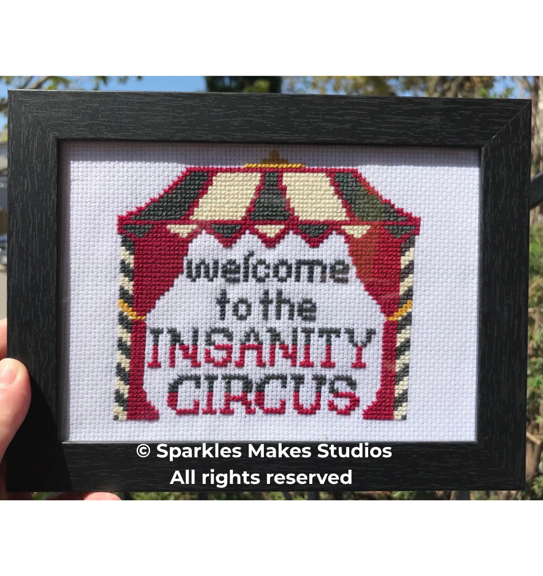 Cross-stitch picture with a circus tent design and the phrase 'welcome to the INSTITTY CIRCUS' in black and red text.