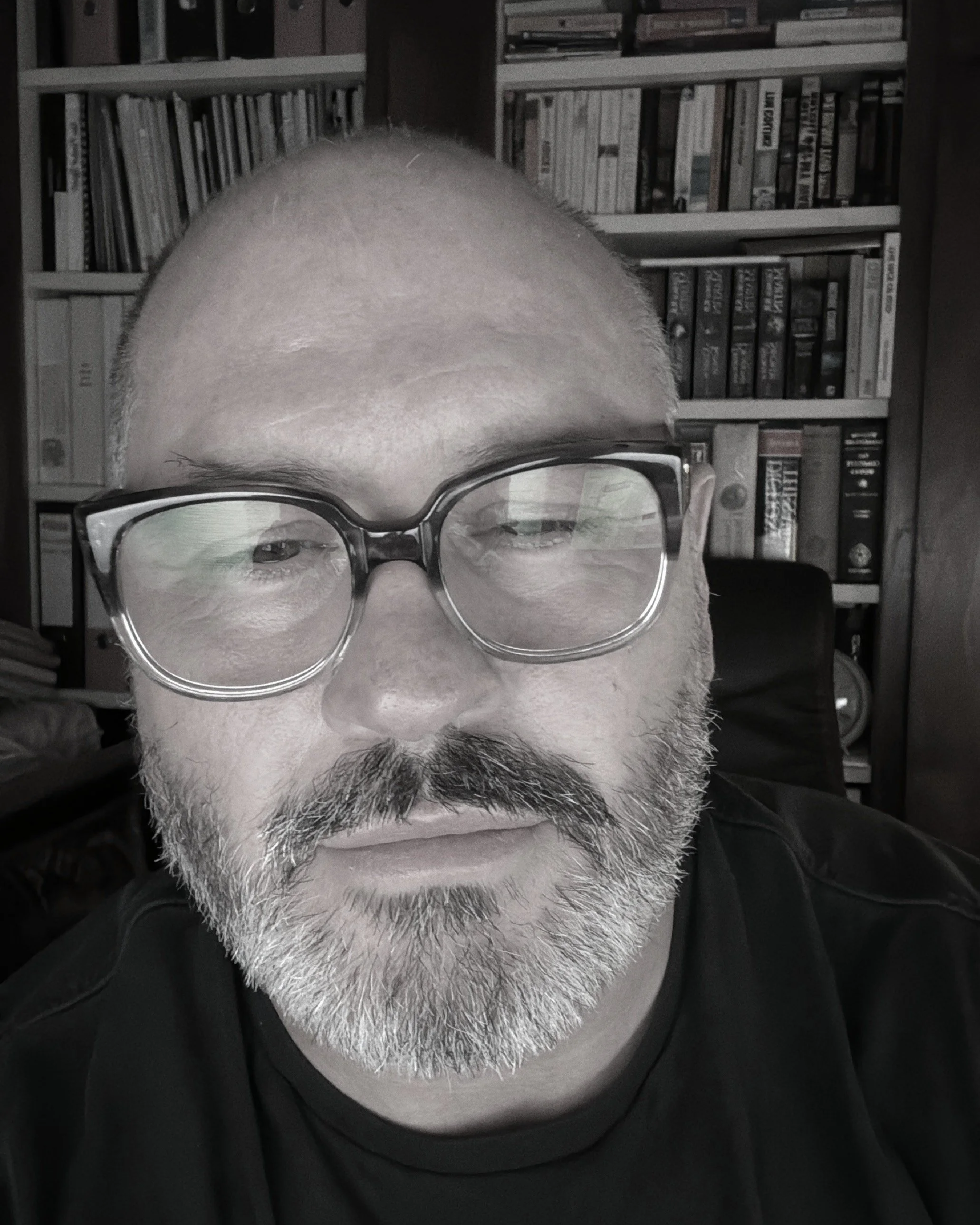 The Author 'Harry Black' in front of bookshelves filled with books. Working on new novels.