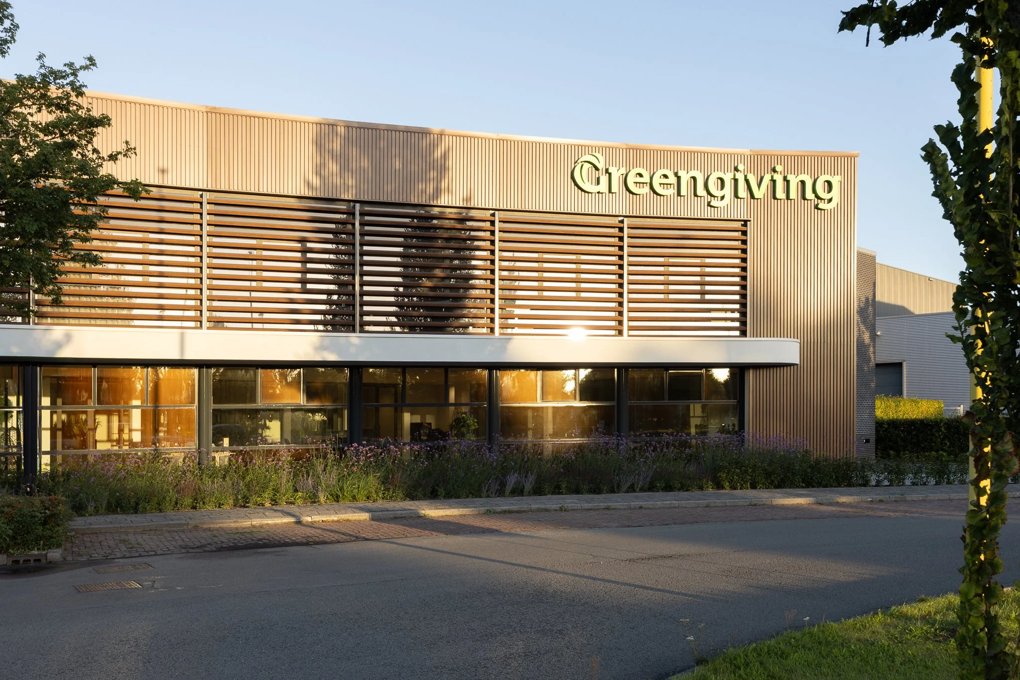 Curved office façade with timber cladding, large windows and architectural sunshades