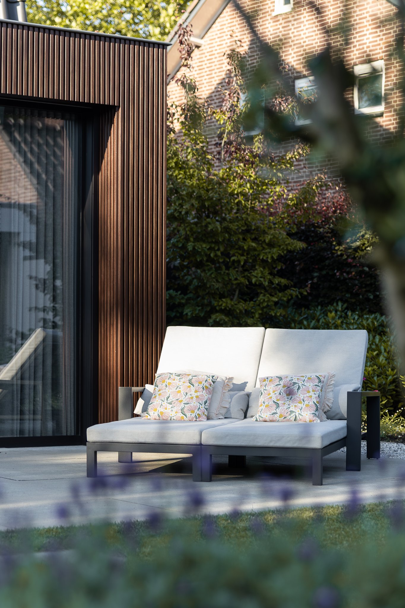 Outdoor lounge seating beside a contemporary timber-clad home extension
