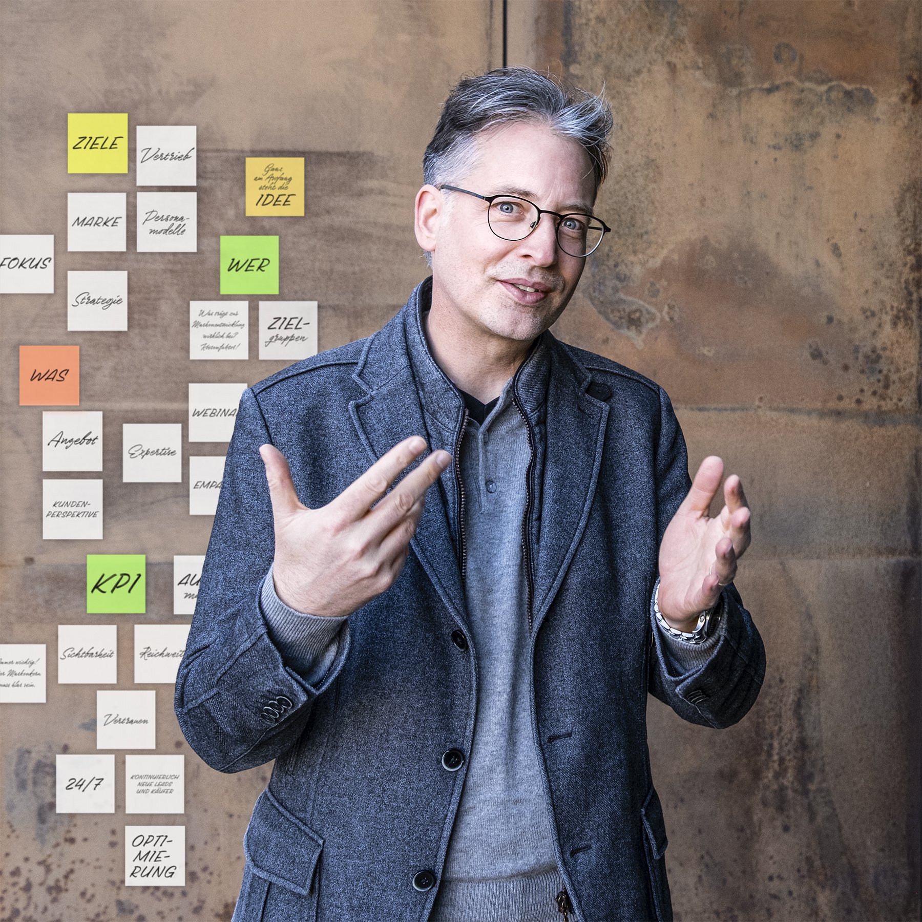 Funnel Experte Florian spricht über Funnel-Strategie, Portrait vor modern-rostiger Wand mit Post-its, Wagner1972