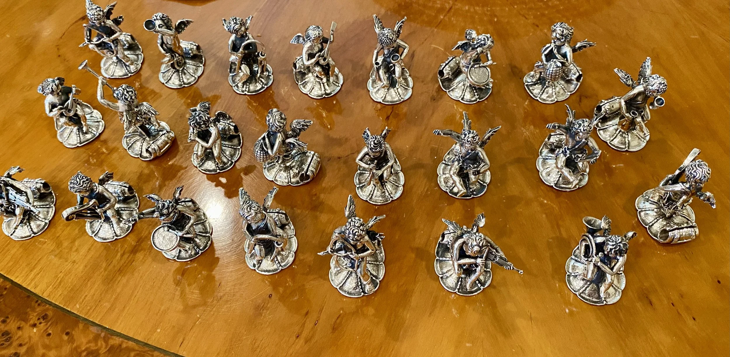 Collection of Silver Place Card Holders in the form of Putti playing musical instruments (maker: Wyler)