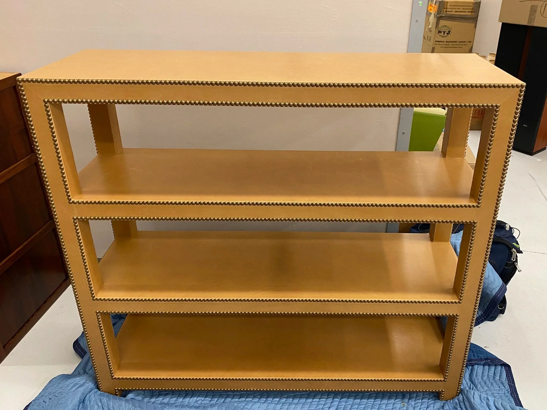 Impressive Custom Fabricated Tan Leather Bookcase with Brass Studded Trim
Size: 50 inches long x 16 inches deep x 44 ½ inches high
