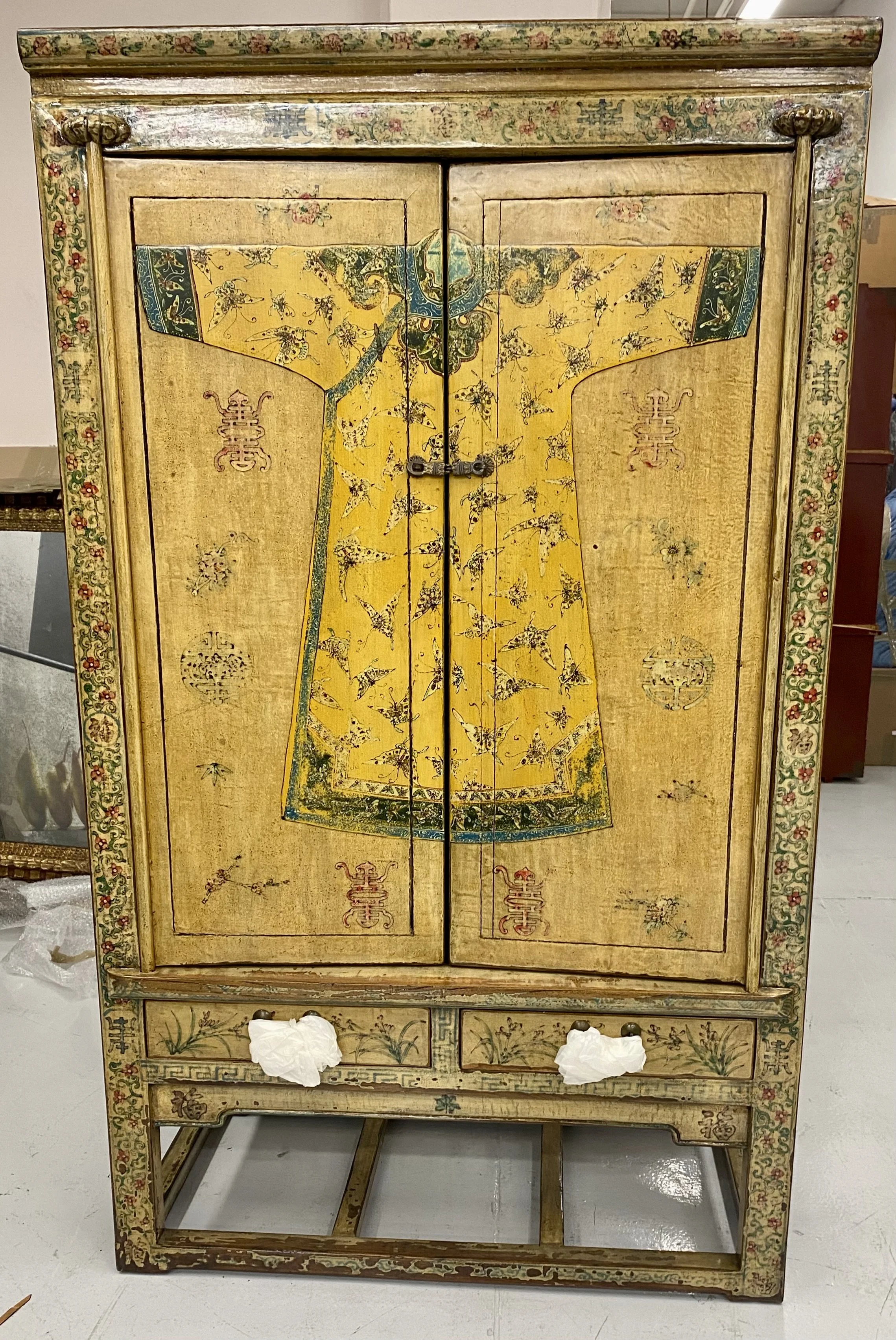Chinese Lacquered Two Door / Two Drawer Cabinet with Yellow Painted Décor featuring a central Robe motif with Floral Trimmed Border
Size: 42 inches wide x 21 inches deep x 70 inches high
