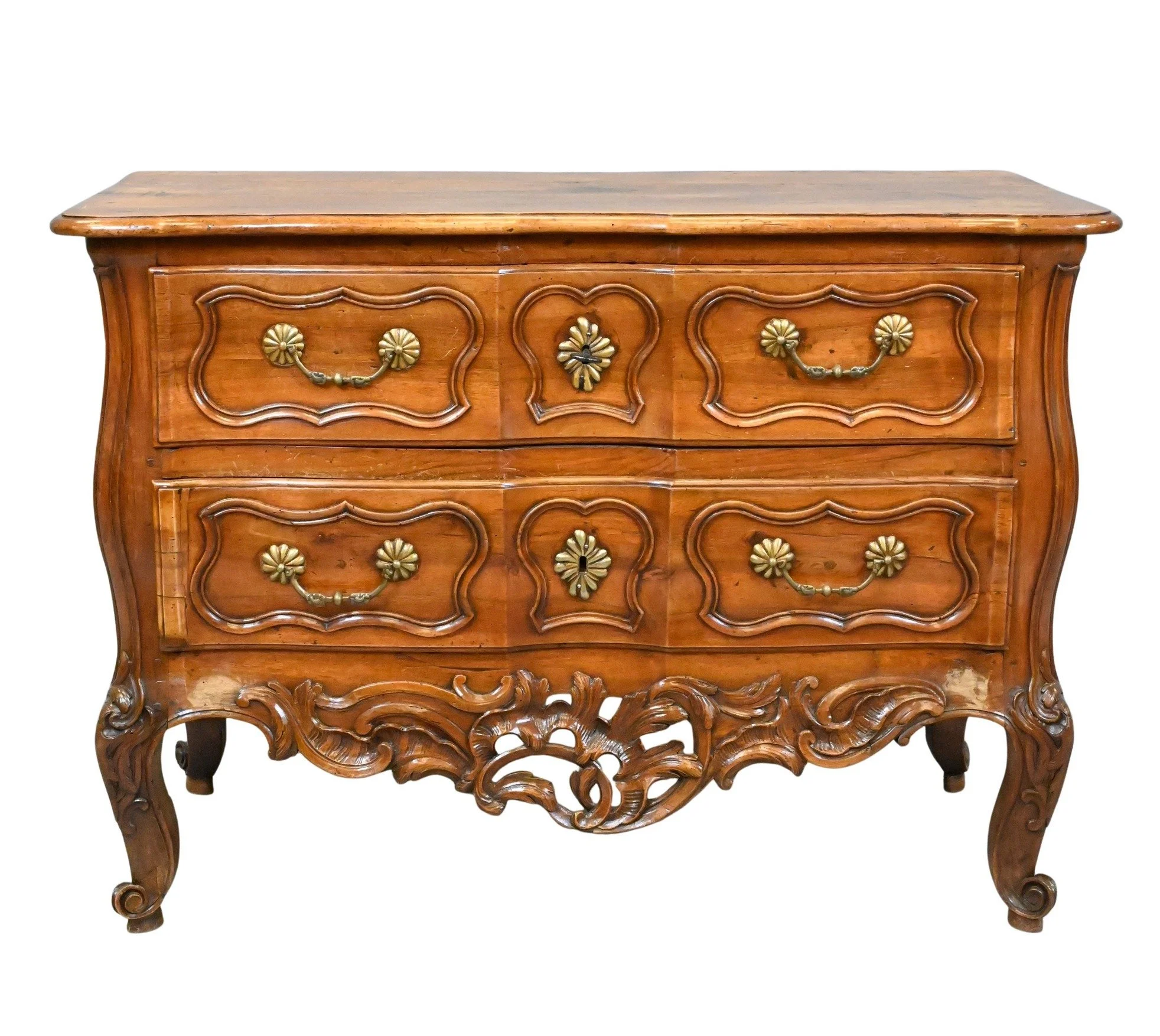 Louis XV Provincial Carved Walnut Commode
having serpentine plank top above two long drawers with molded panels and brass rococo handles, shaped apron carved with scrolling foliage, cabriole legs ending in scrolled toes, and sides with molded and pie