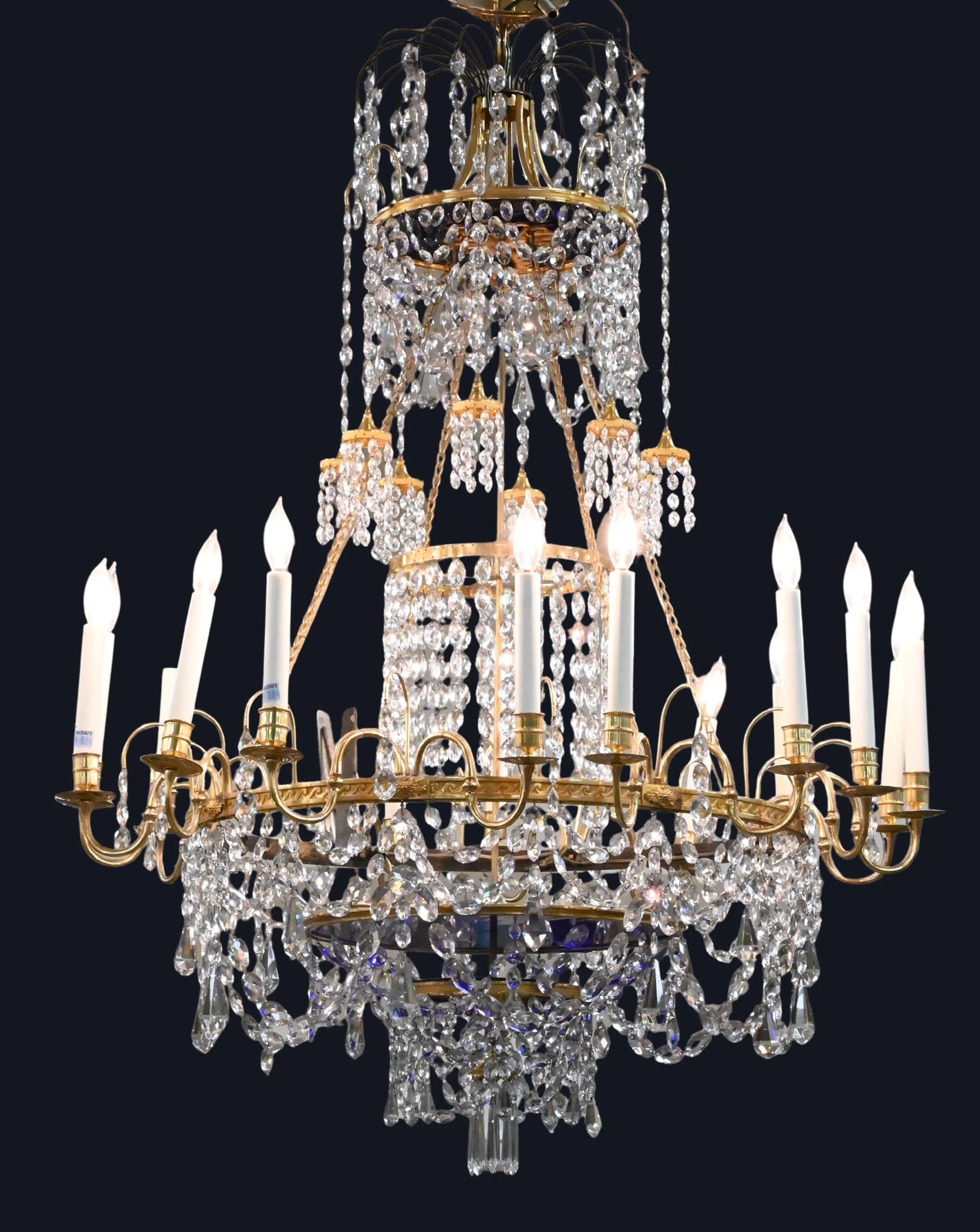 Swedish Gustavian Sixteen-Light Crystal Chandelier with Cobalt Glass Centers
impressive sixteen-light chandelier with scrolling gilt-metal arms, each supporting a candle nozzle, surrounding a dramatic pair of deep cobalt-blue glass bowls, the frame r