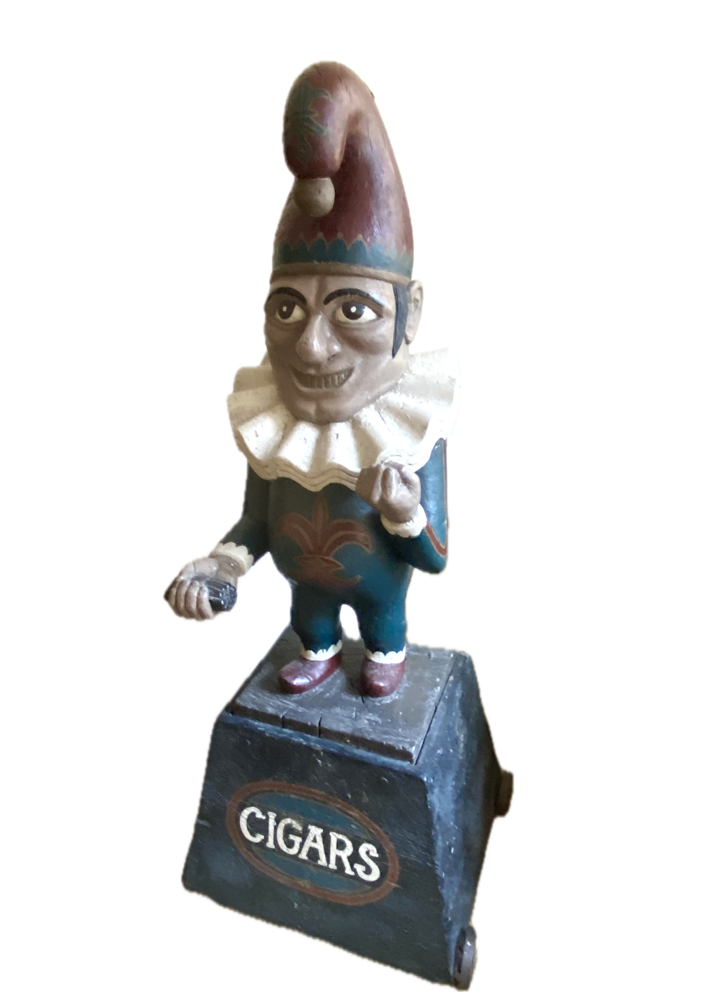Carved wood and polychromed figure of Punch, 20th Century;
The figure stands with a pack of cigars in the right hand on a shaped tapering base,
Labeled “Cigars” and set on an iron base.
Overall Height: 60 ½ inches
