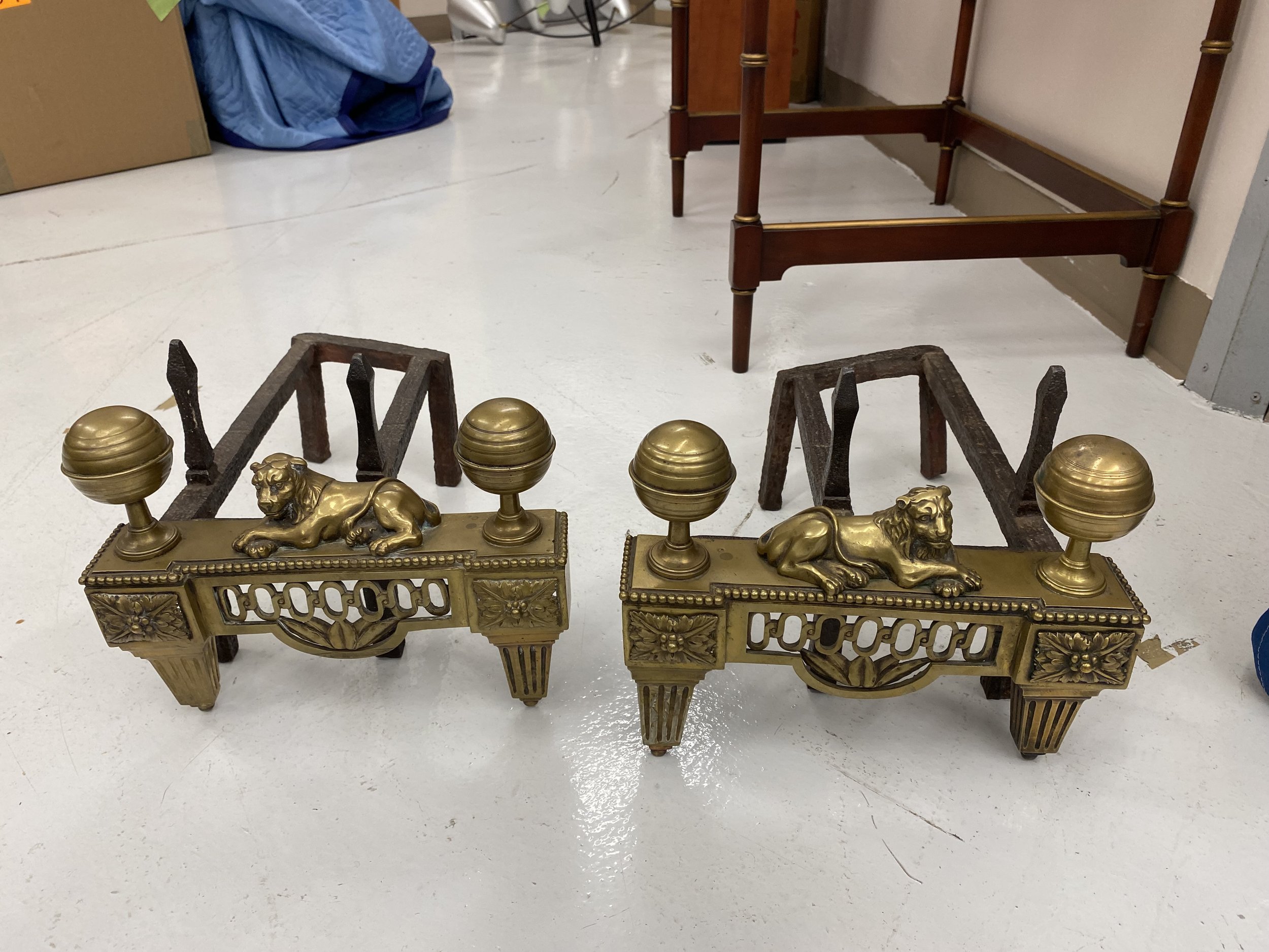 Pair of Bronze Andirons with Recumbent Lion Motif. 
Size: 12 inches wide 
