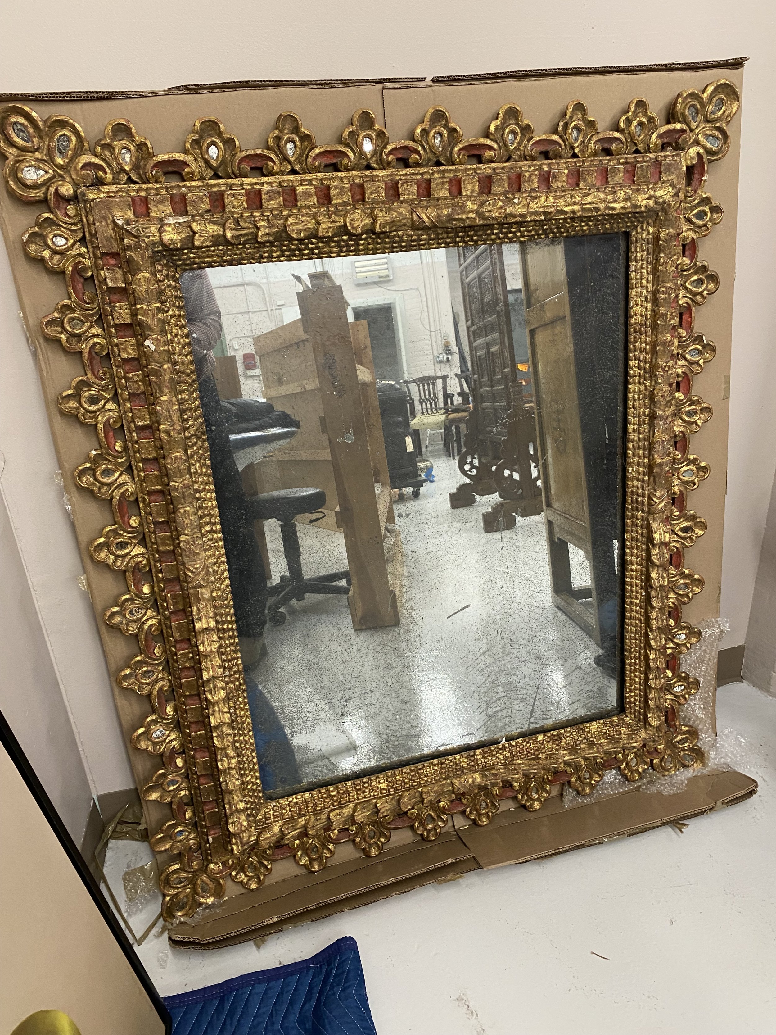 Impressive Baroque Spanish Parcel Gilt and Red Painted Mirror, Early 18th Century; the rectangular mirror plate within a frame composed of a ripple molded border, a leaf-tipped band, and pierced C-scroll trefoil border set with mirror glass oval.
Siz