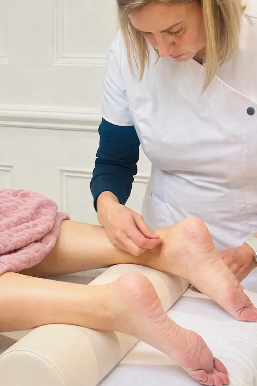 Nickila Robertsson acupuncturist and owner of NRQi Studio in Winchmore Hill, North London N21 performing acupuncture on a patient's leg.