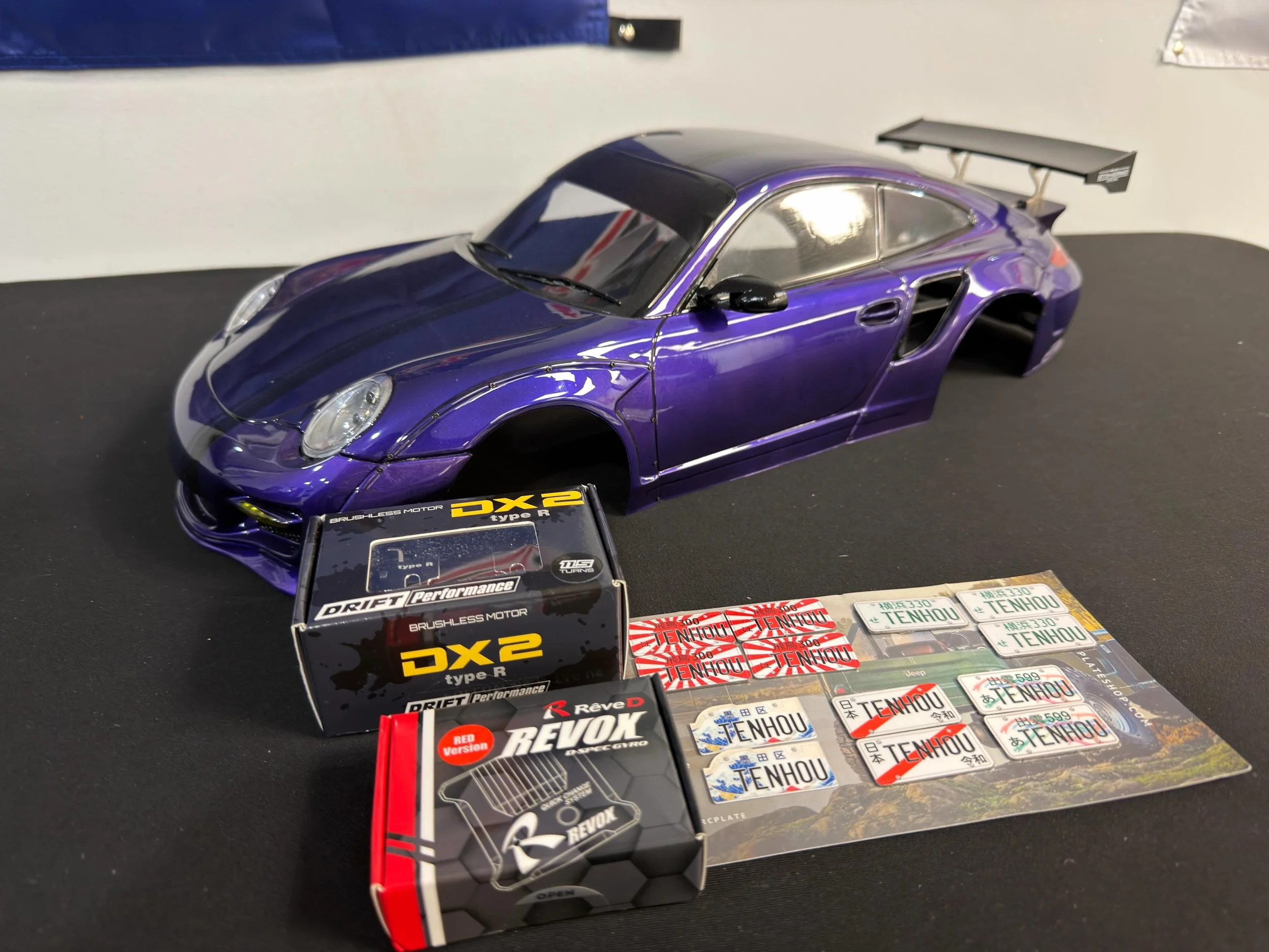 Raffle prizes for our Grand Opening Matsuri! Metal scale license plates for your RC drift cars, a Reve D Revox gyro, a Yokomo DX2 11.5T motor, and the grand prize is this absolutely beautiful Porsche shell built by @sittinsidewayz_imposter! We will s