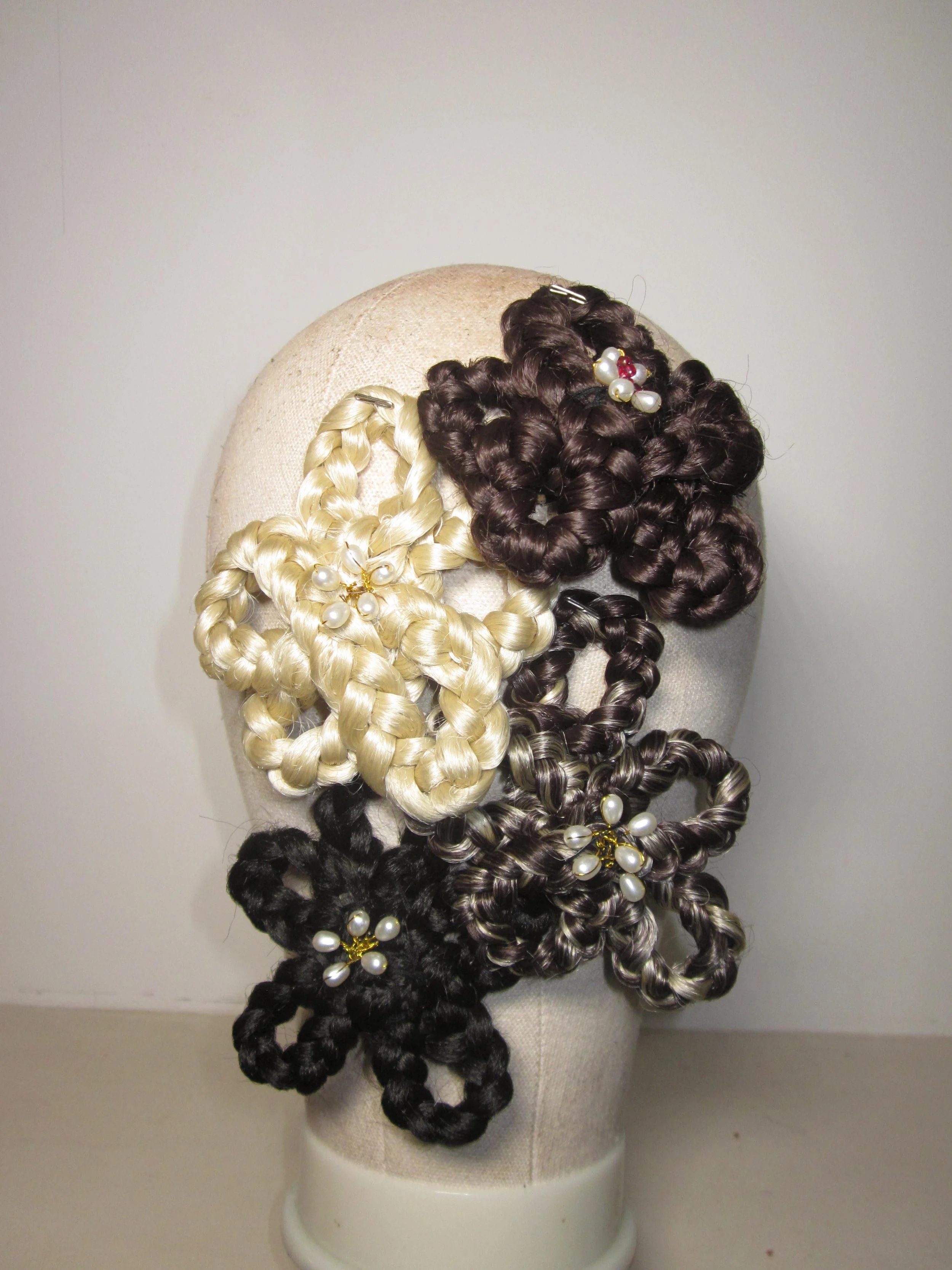 A modern backyard with a swimming pool, lounge chairs, a patio with outdoor furniture, landscaped garden with purple plants, and a house in the background, set against rolling hills and a clear sky.