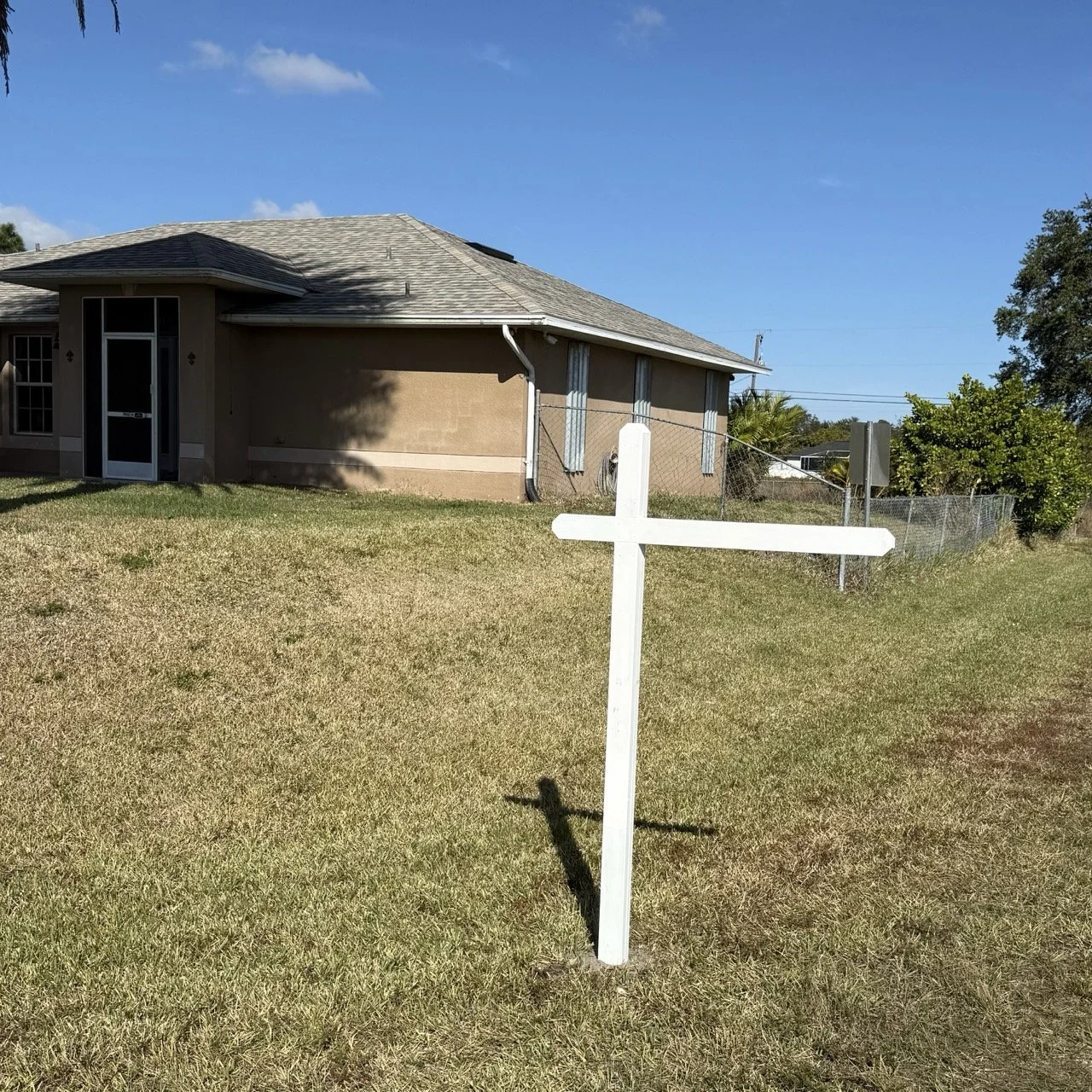 Image of a white sign post in-front of a house