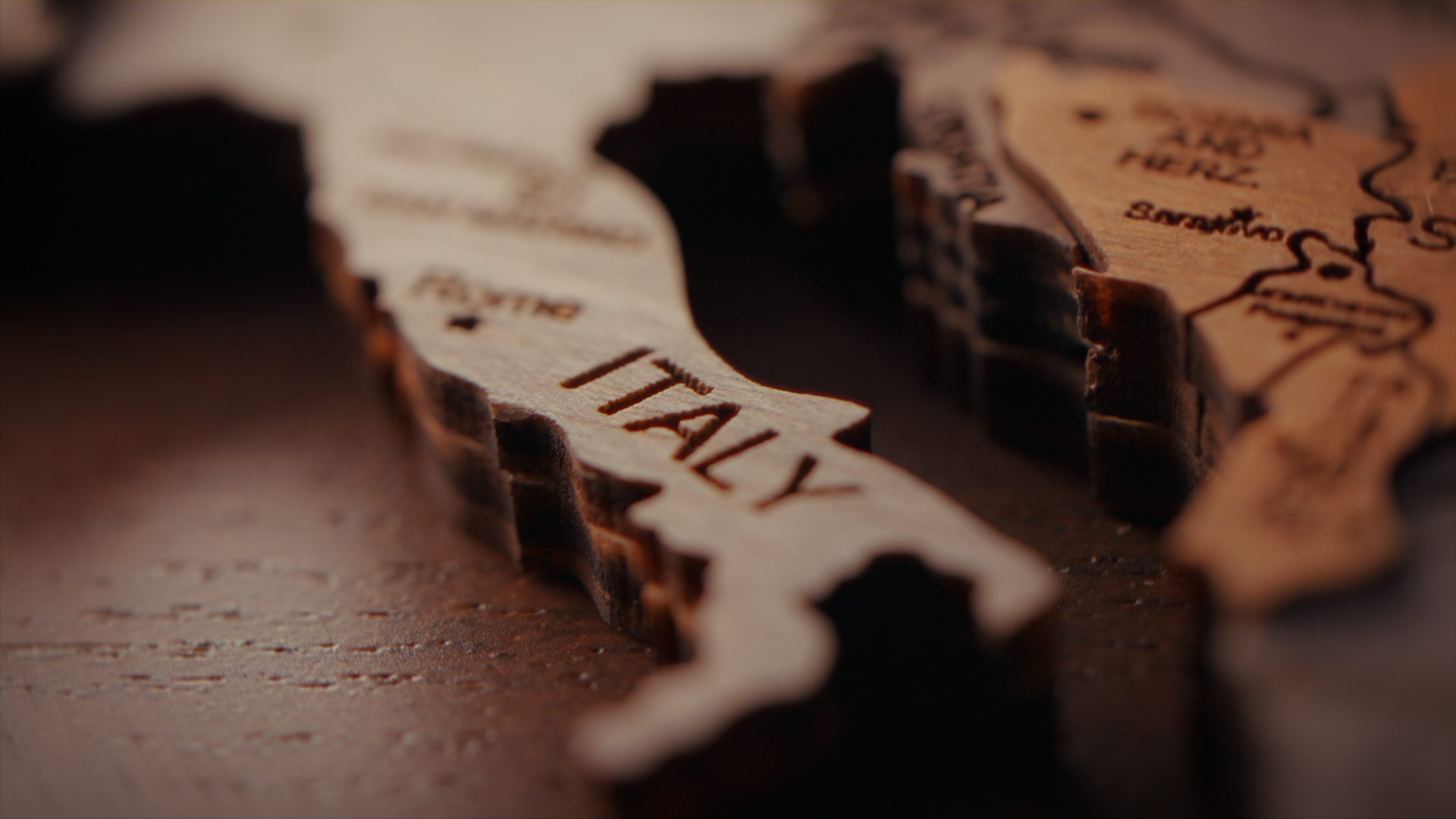 Mappe in legno con la parola 'ITALY' incisa, in primo piano.
