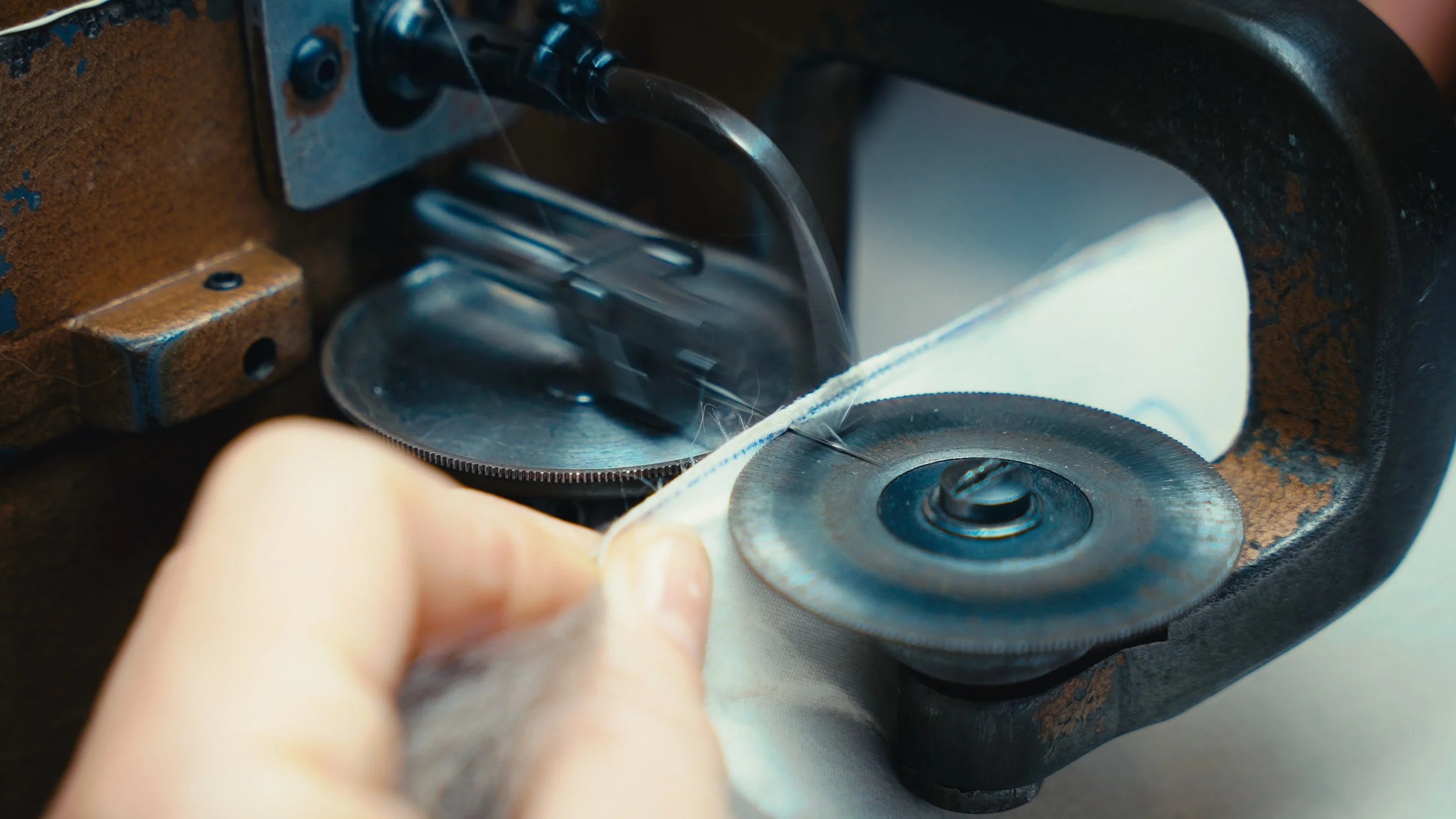 Lavoratore che taglia dei tessuti con una sega circolare.