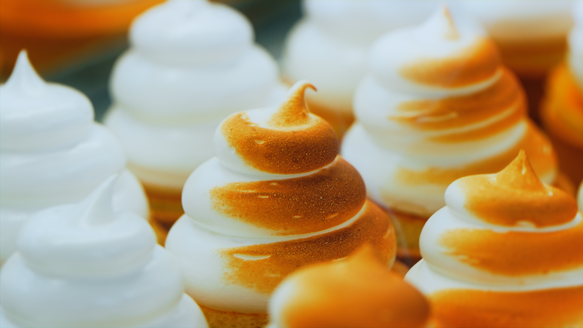 Meringhe bianche e marroni disposte in file.