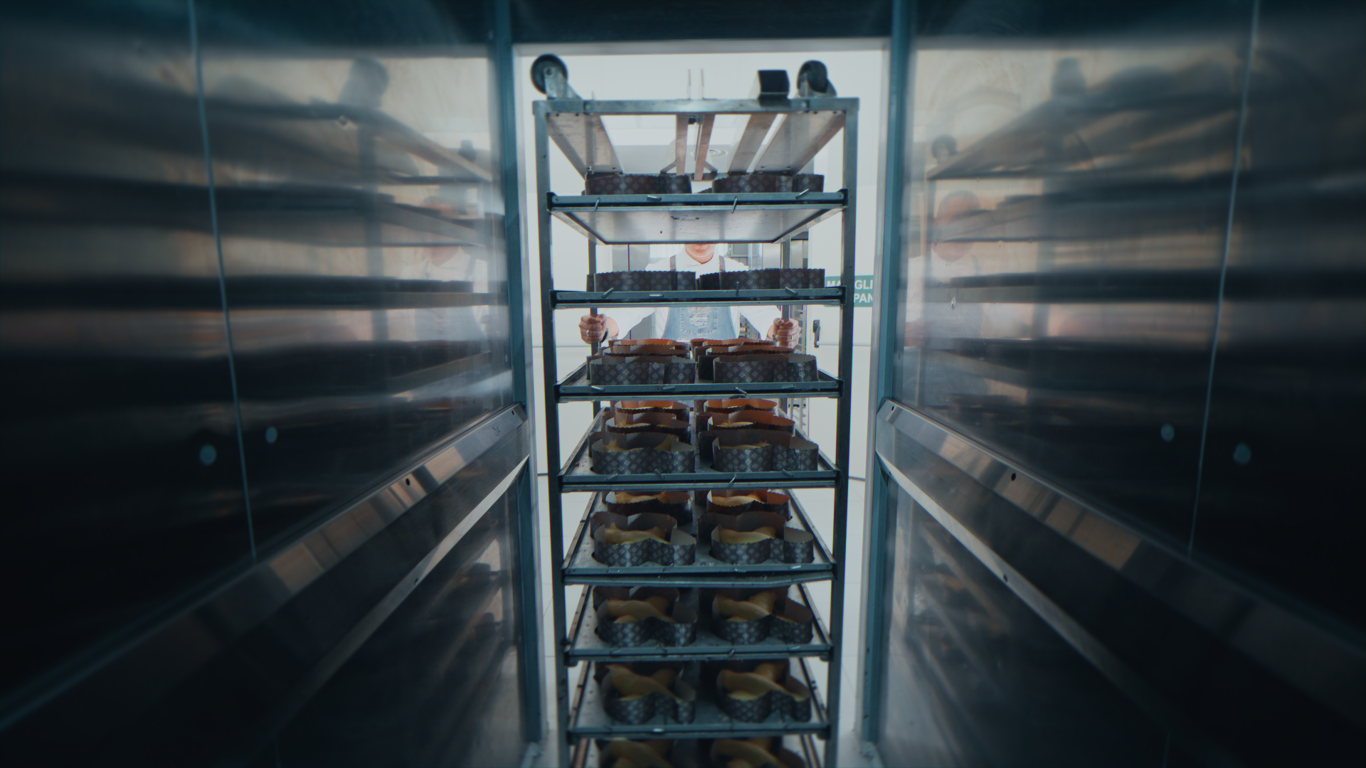 Operatore che trasporta torte all'interno di un forno industriale.