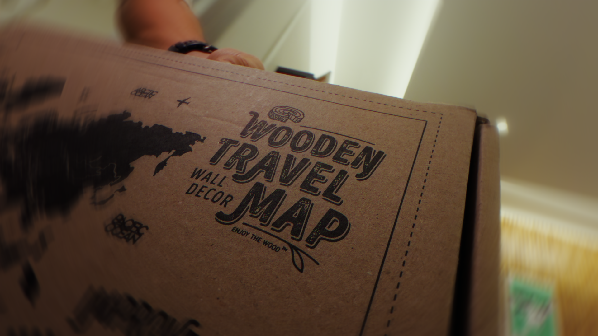 Immagine di una scatola di decorazioni in stile legno con la scritta 'Wooden Travel Map Wall Decor', una mappa stilizzata e alcuni dettagli di testo."