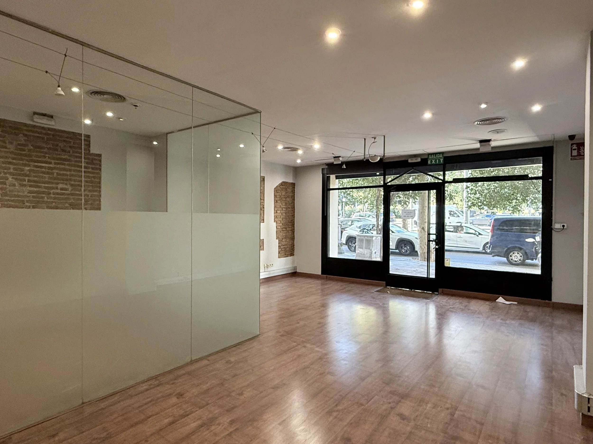 Espacio interior con paredes de ladrillo expuesto, suelo de madera y un área con paredes de cristal parcialmente frosted, con un cartel que dice 'LEVELS' y una ilustración de escaleras.