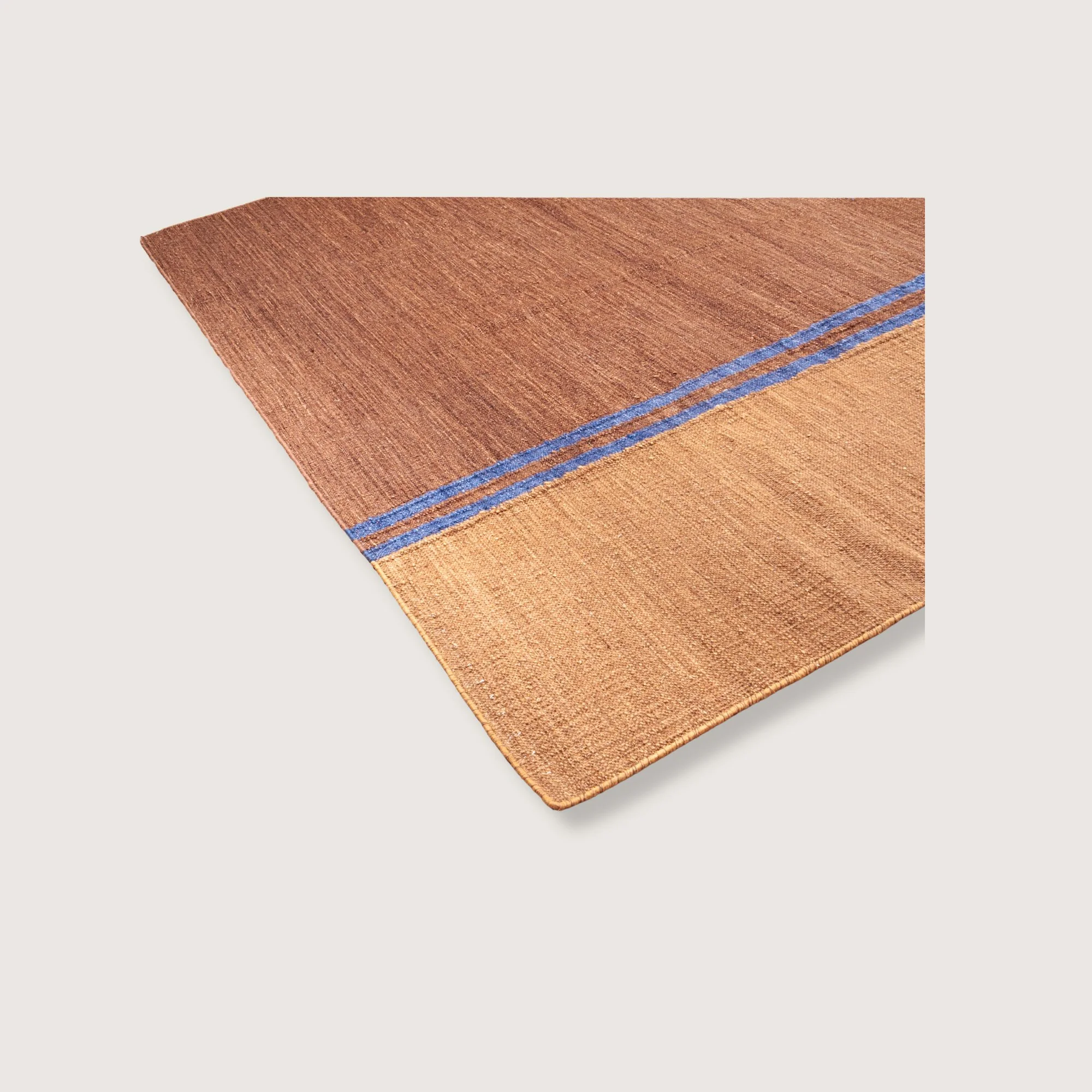Angled view of Rekha Do handwoven rug with double blue line detail and natural wool texture