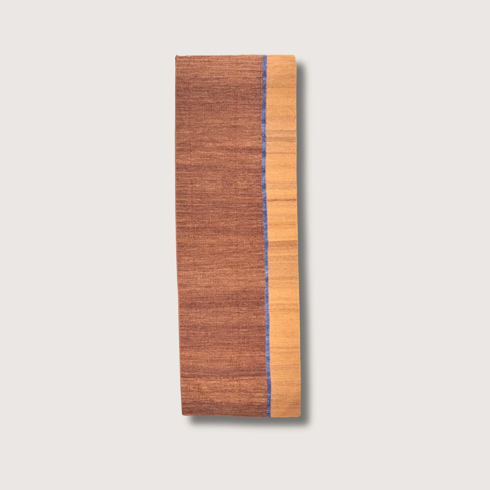 Rekha Ek handwoven wool runner with brown tones and a single blue vertical line, minimal flatweave design