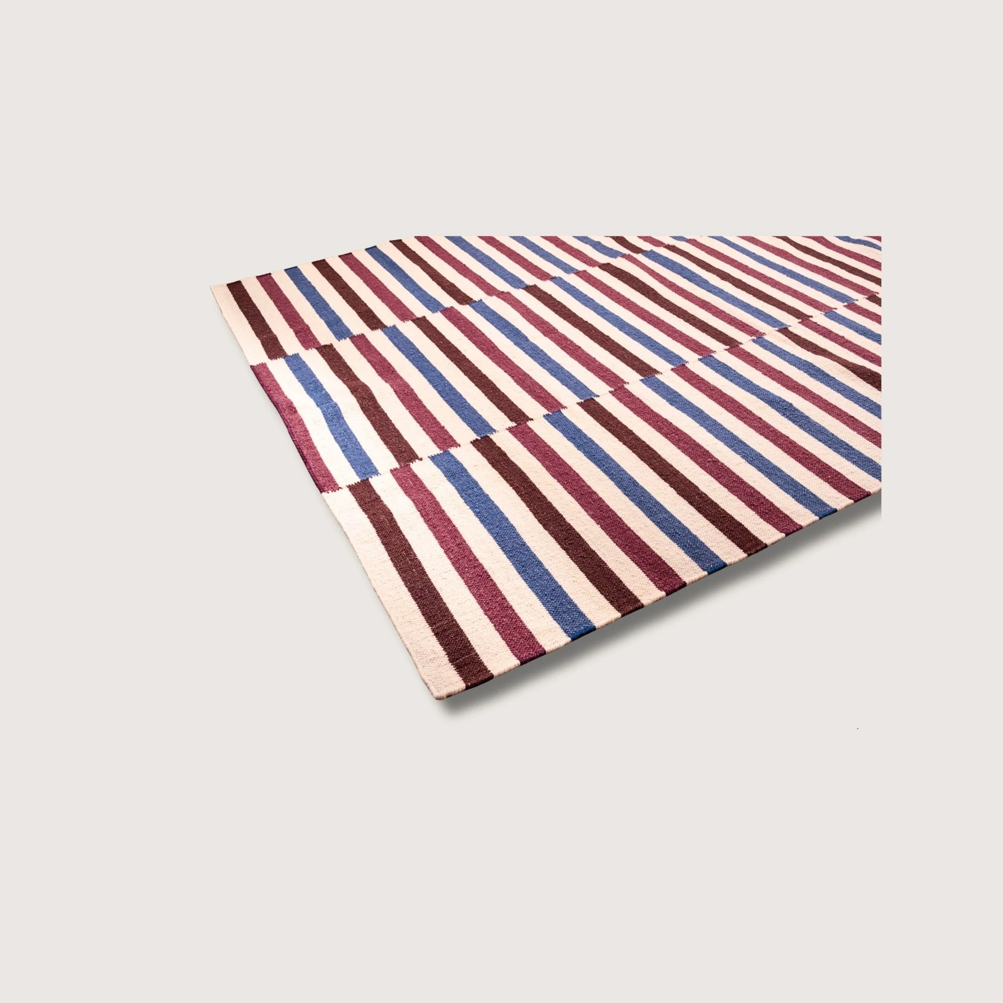 Angled view of Saanjh rug with multicolor stripe detail and natural wool texture