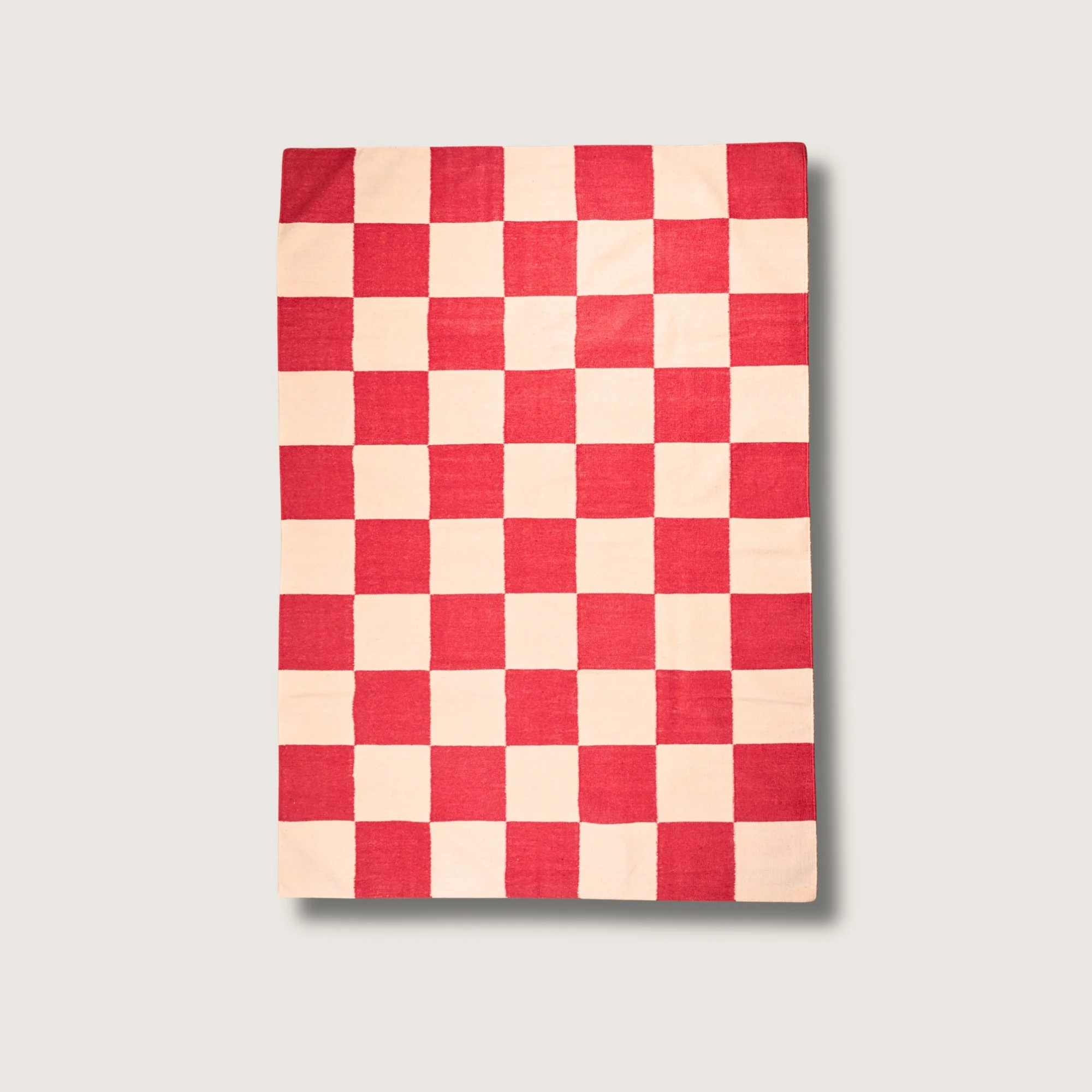 Khana Laal handwoven checkered wool rug with red and natural squares, bold flatweave design