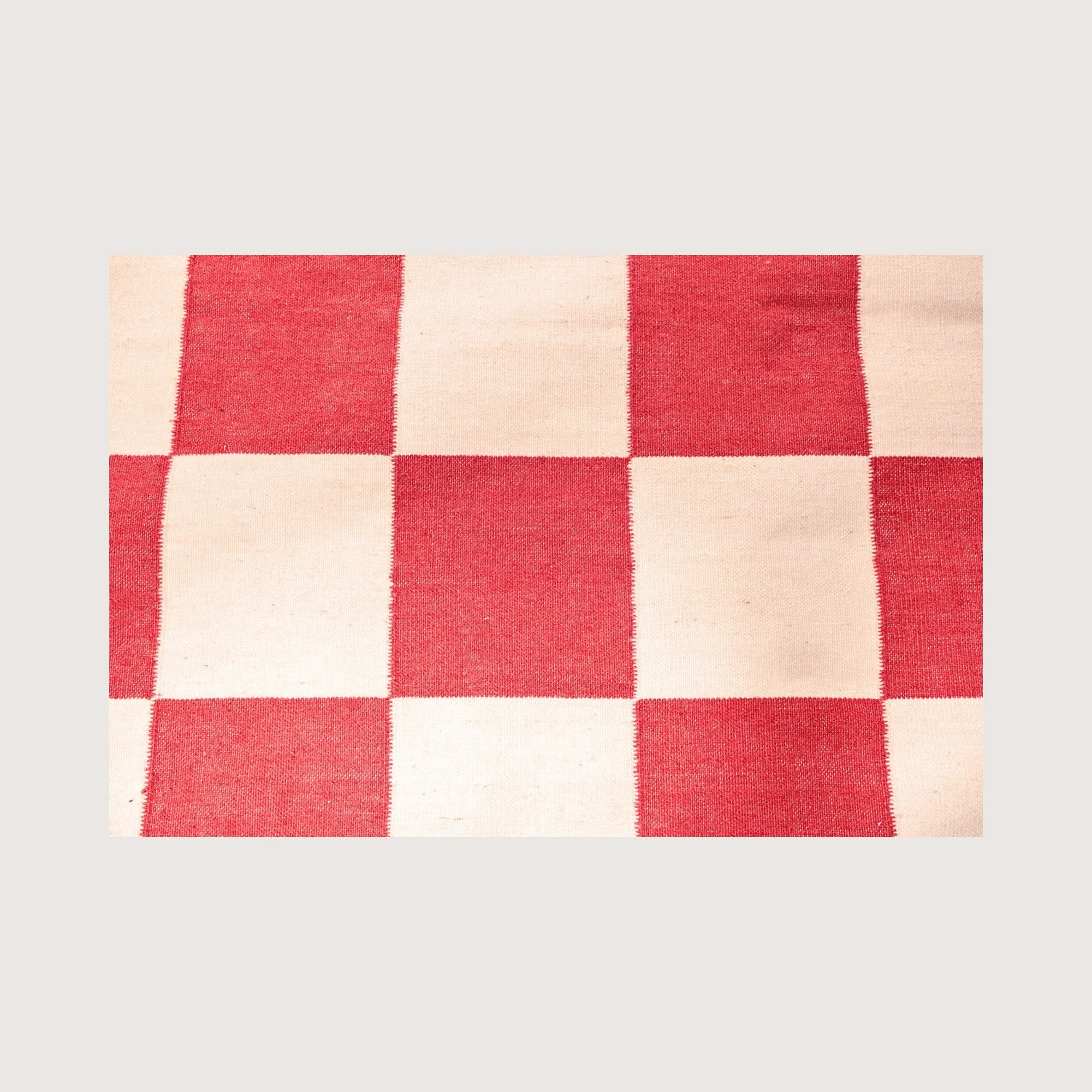 Close-up of Khana Laal rug showing handwoven texture and checkered pattern