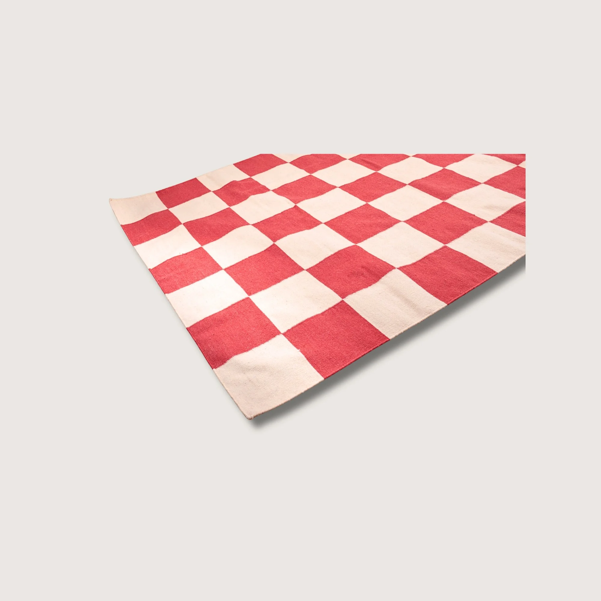 Angled view of Khana Laal rug with red square detail and natural wool texture