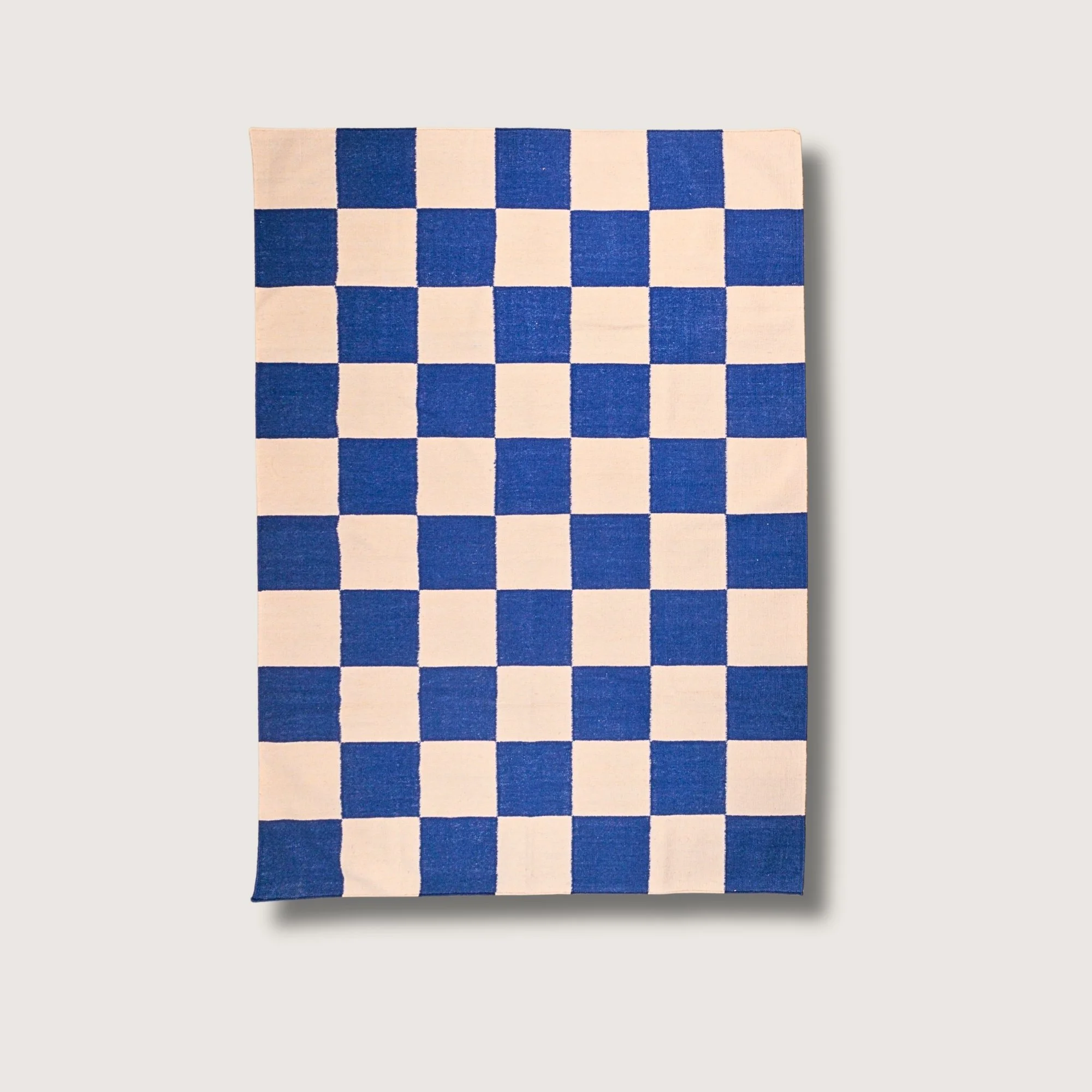 Khana Neel handwoven checkered wool rug with blue and natural squares, flatweave design
